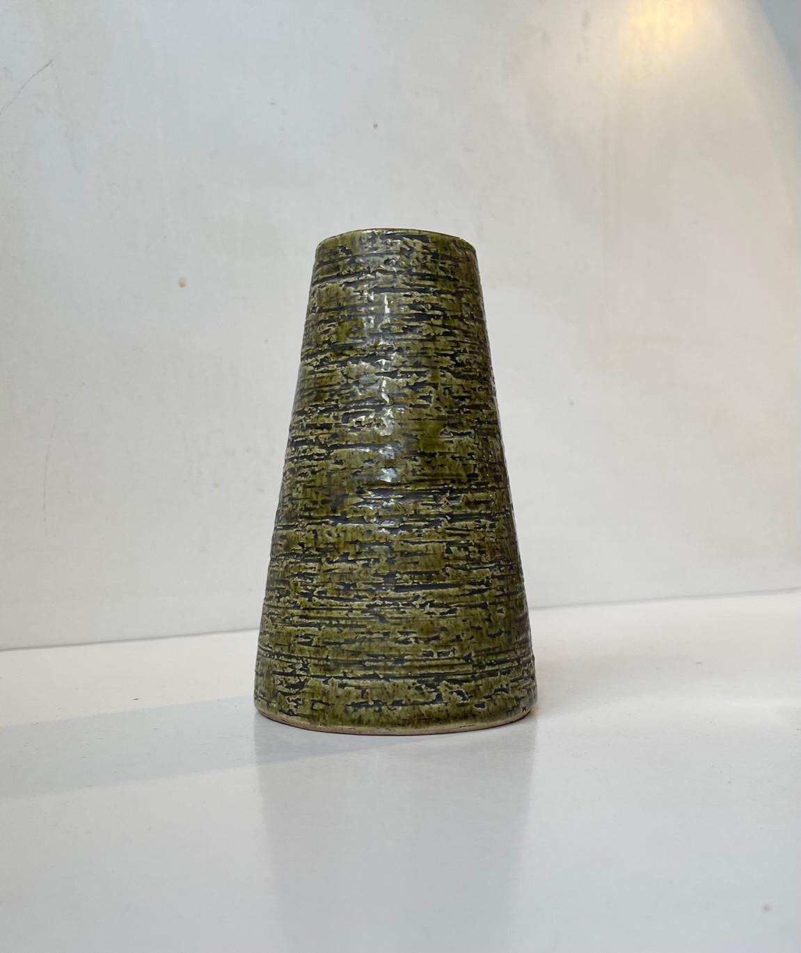 Questo vaso in gres Chamotte con smalto verde oliva/piccante è stato disegnato dal ceramista svedese Gunnar Nylund e realizzato in Svezia negli anni '60. Marcature: Svezia, 471, 2 e GN a matita sbiaditi e molto indistinguibili. Misure: altezza: 15