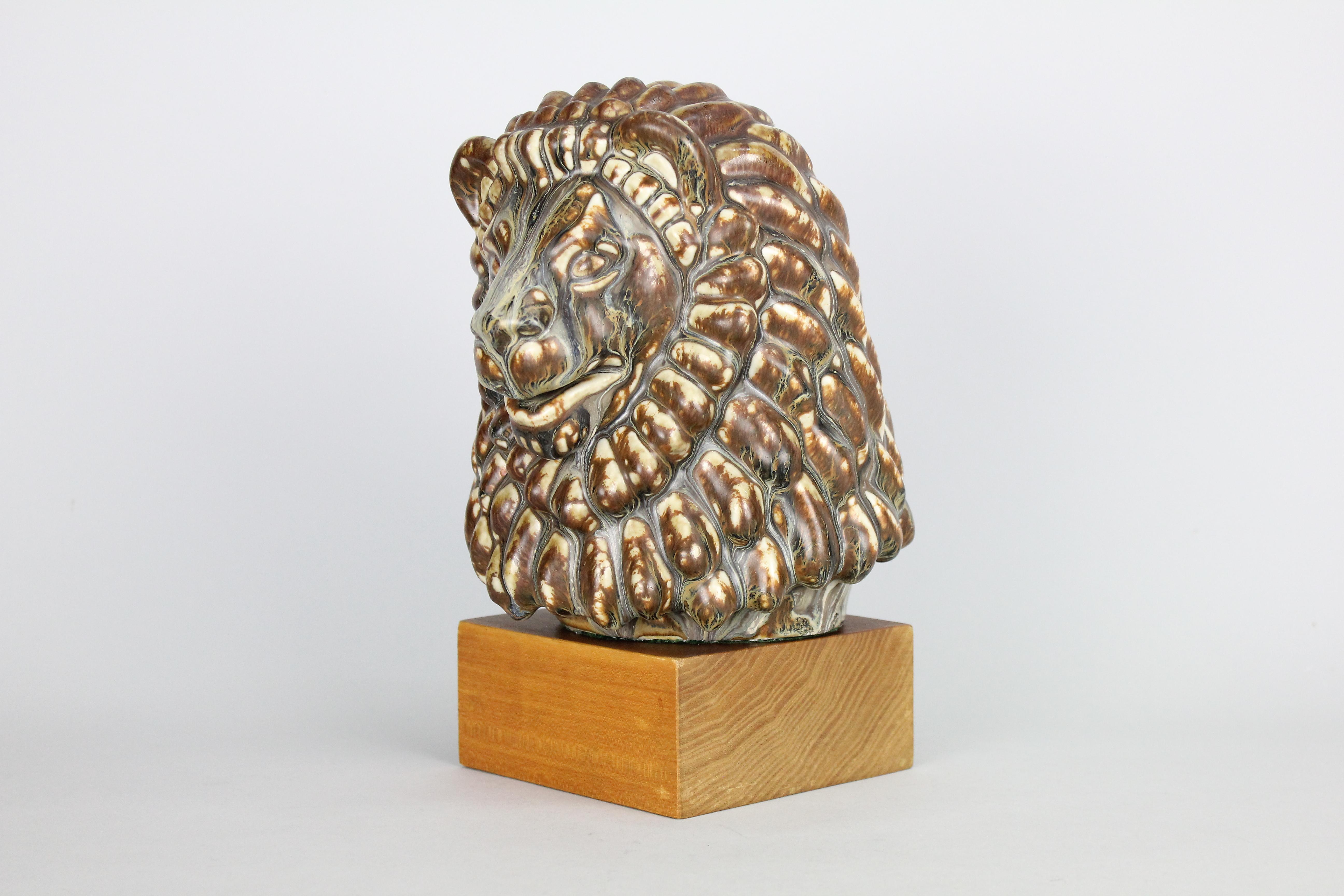 Stunning lions head by Gunnar Nylund for Rörstrand. The condition, glaze, and the colors are exquisite.
Fully signed with Gunnar Nylund initials and Rörstrand mark.
The lions head can be on the wooden base or standing on its own.
The base is