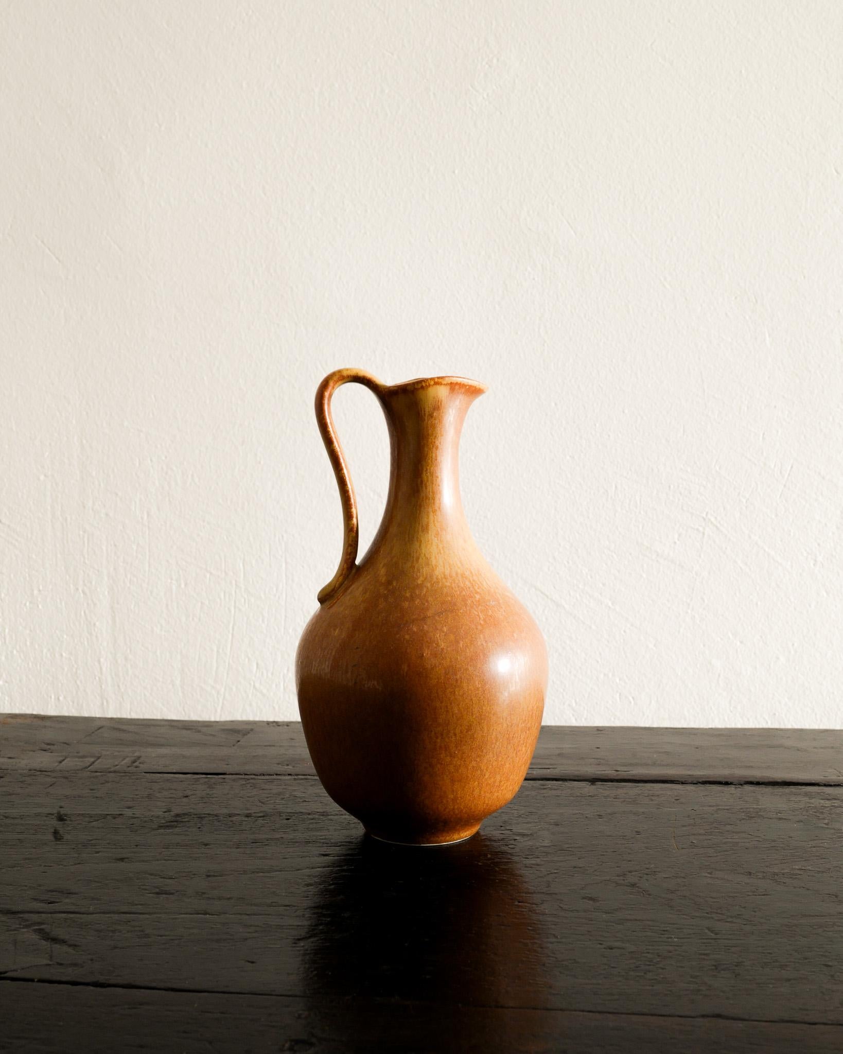 Rare brown mid century ceramic pitcher by Gunnar Nylund for Rörstrand, Sweden 1950s. In good vintage condition with some signs from age and use. Signed and numbered. 

Dimensions: H: 17 cm / 6.70