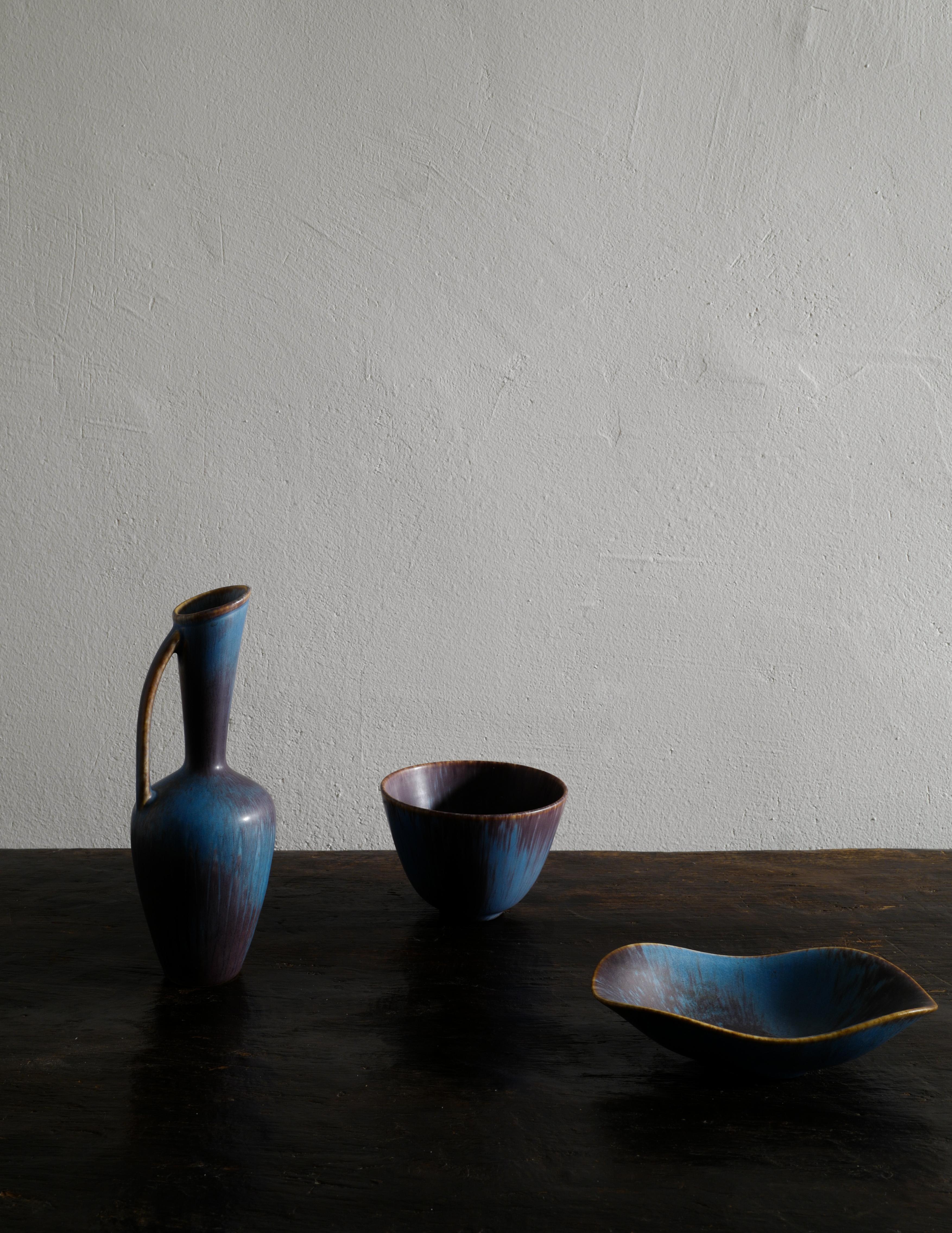 Rare and beautiful trio ceramics designed by Gunnar Nylund and produced for Rörstrand in Sweden in the 1950s. All are in good vintage condition and matching well together. All signed. 

Dimensions:
Pitcher: H: 23 cm W: 8 cm D: 8 cm
Bowl: H: 9 cm