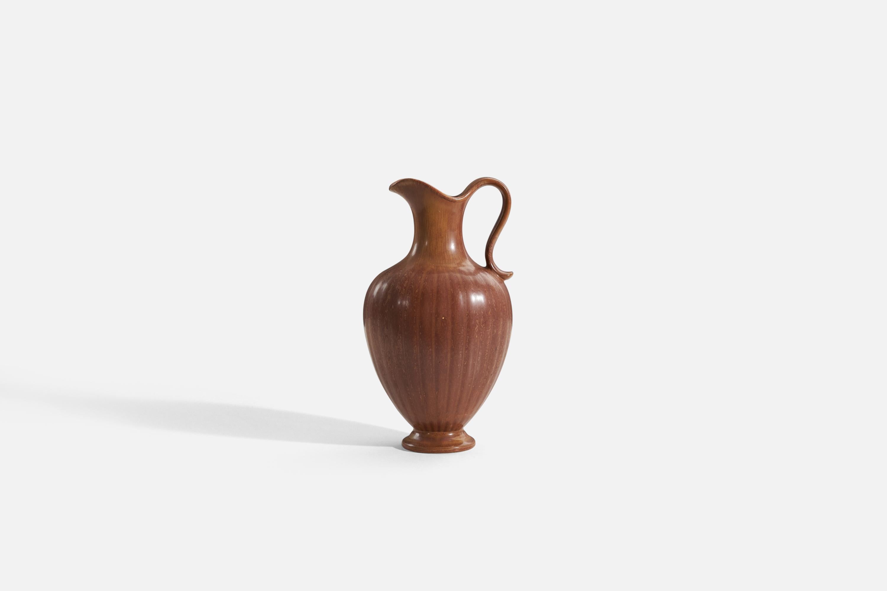 A brown stoneware pitcher produced by Rörstrands, Sweden, 1950s.
   