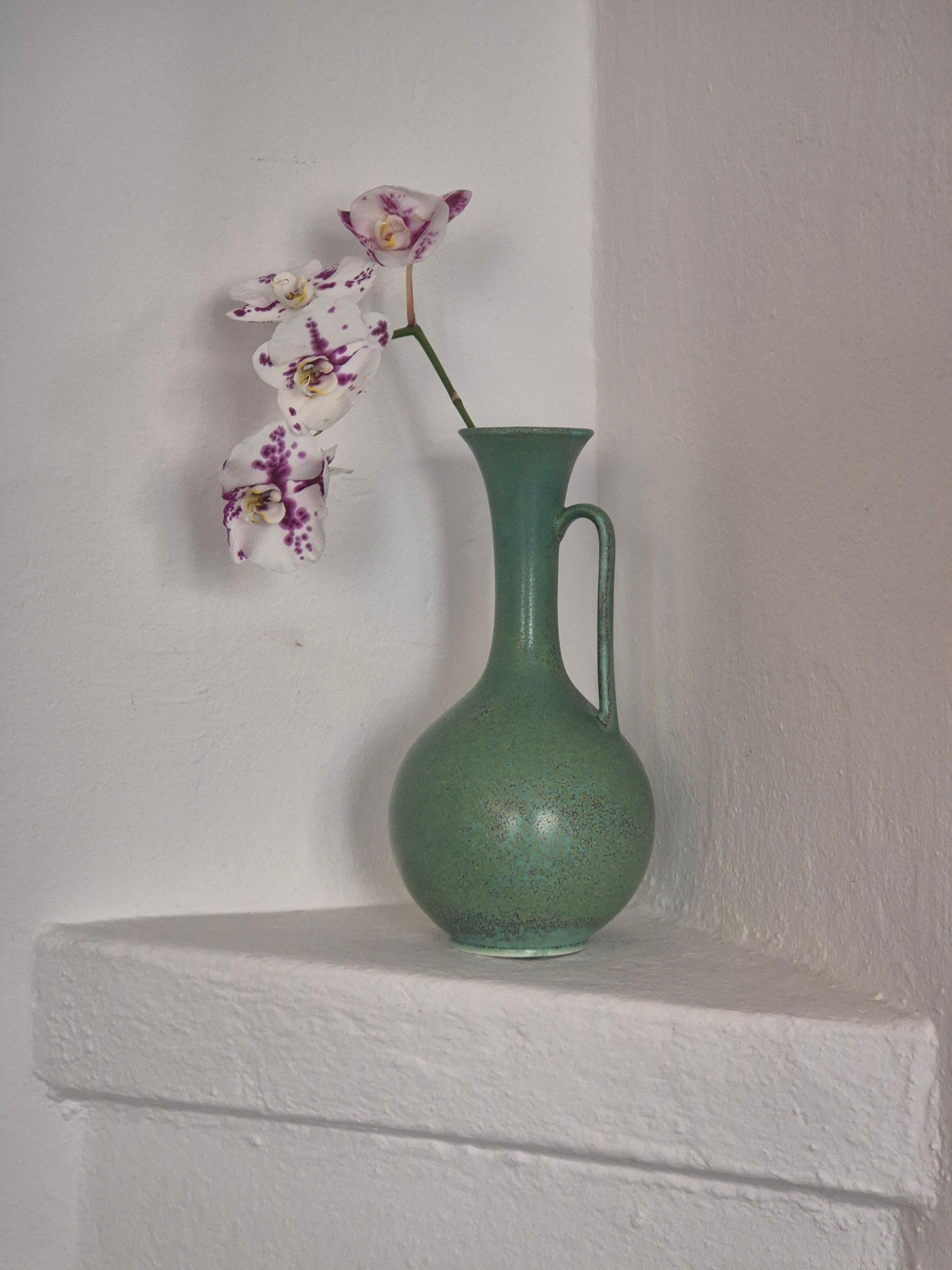 Beautiful decorative carafe / vase in ceramic by Gunnar Nylund for Rörstrand, Sweden, Mid-1900s. A rare shape with a wonderful light green with spots of dark blue and grey. 

Signed. In good condition, normal minimal makers defects and smaller signs