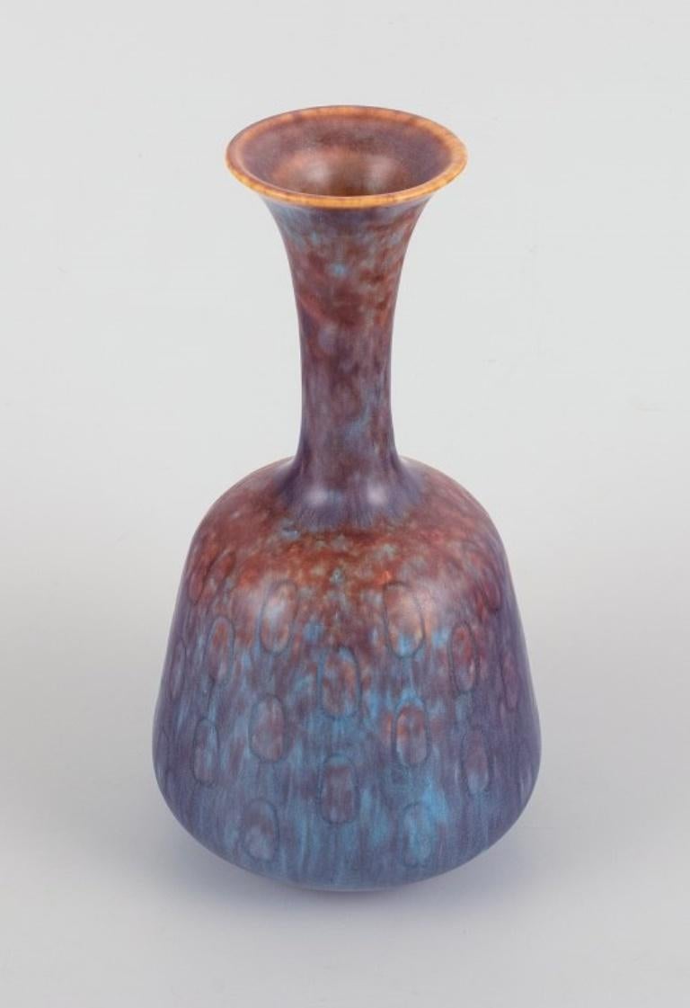 Gunnar Nylund for Rörstrand. Ceramic vase with a narrow neck in blue-violet glaze. 
Produced in the 1960s.
Stamped with the manufacturer's mark. 
Second factory quality.
In excellent condition. 
Dimensions: H 15.5 cm x D 8.0 cm.