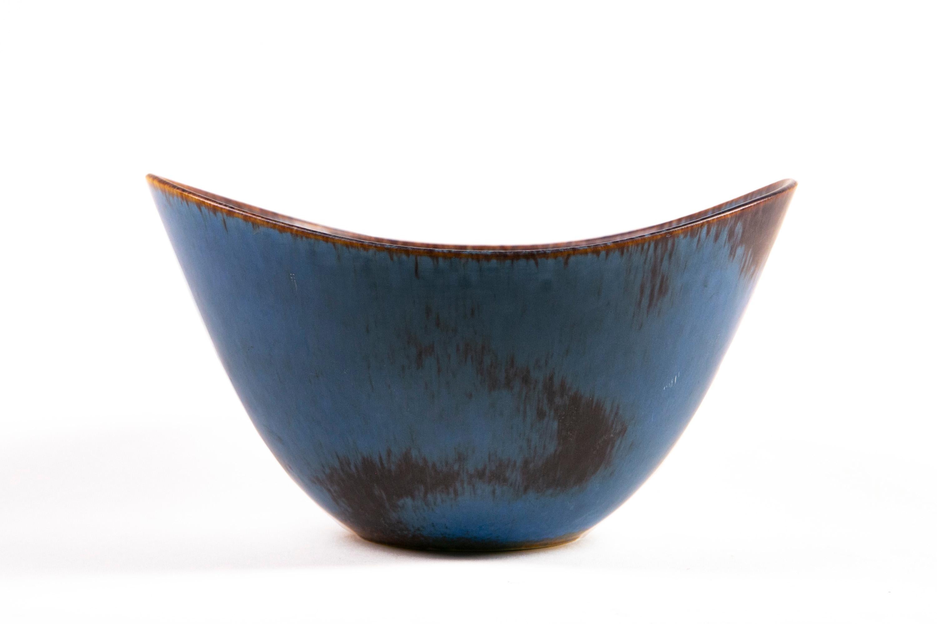 Gunnar Nylund Rörstrand large AXK bowl blue an Ocher Hares Fur glaze Sweden 1950.

This unique and large stoneware bowl is glazed with a delicate yet bold blue hares fur glaze with a complimenting ochre rim highlight was made by Rörstrand and