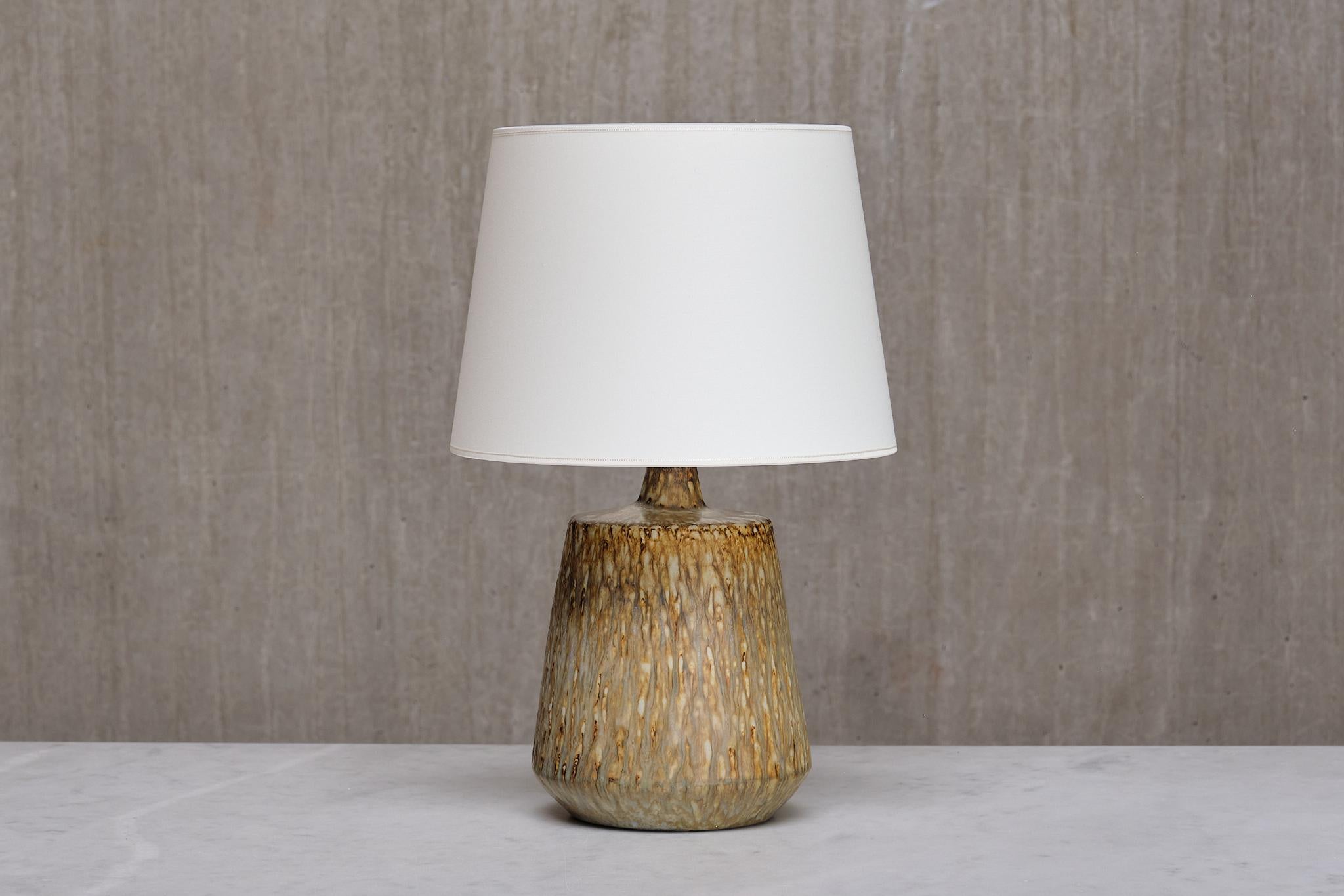 Cette lampe de table remarquable a été conçue par Gunnar Nylund et produite en Suède dans les années 1960. Nylund, réputé pour avoir conçu de nombreux classiques pour l'usine de céramique suédoise Rörstrand, a créé l'une de ses séries les plus