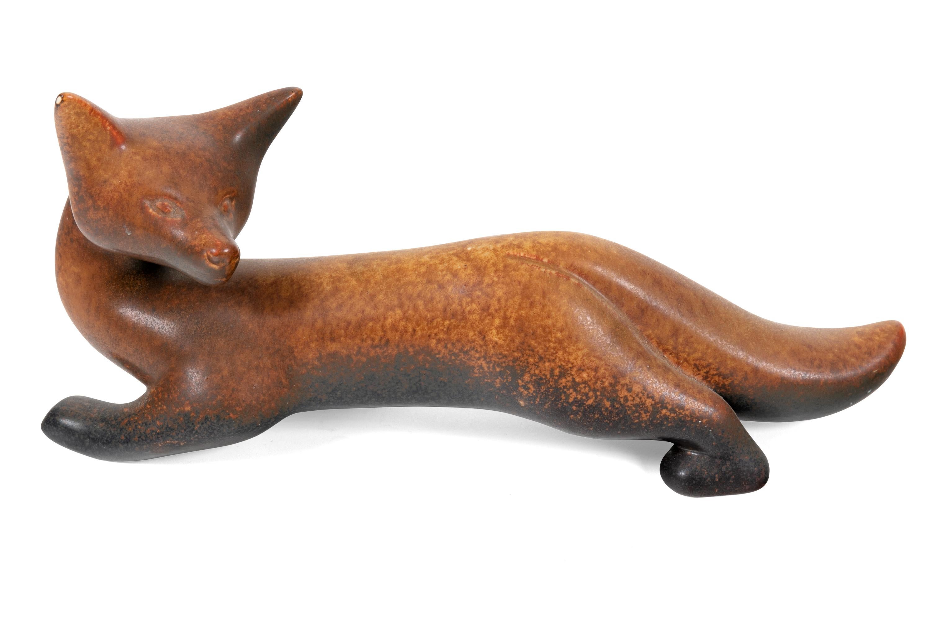 This figural piece of stoneware is playful in its form and glazed in a beautiful matte finish. There is a white spec of a glaze miss on the tip of the left ear of the fox that was in the making.