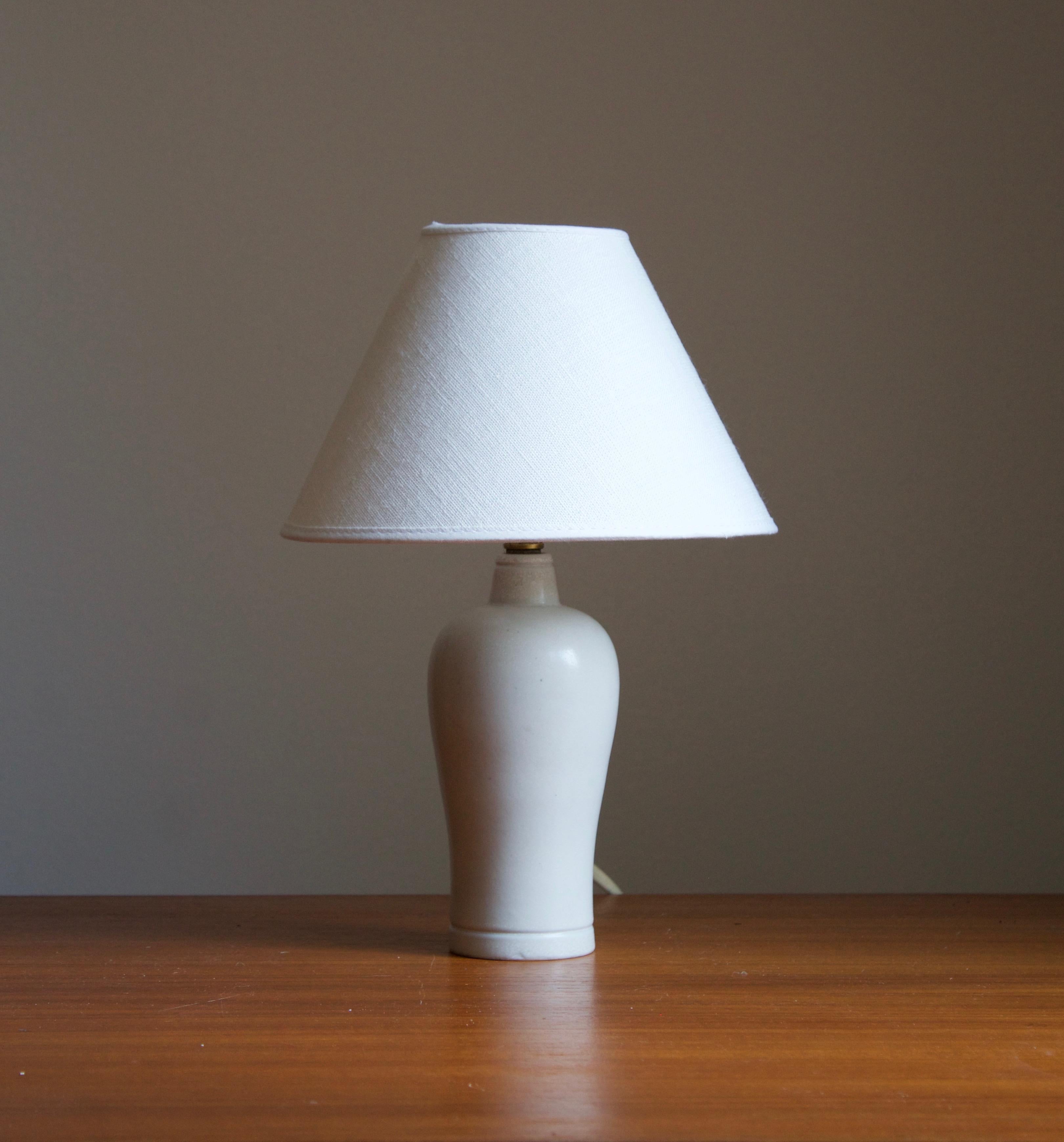 A table lamp produced by Rörstrand, Sweden, 1950s. Designed by Gunnar Nylund, (Swedish, 1914-1997). Signed. 

Stated dimensions exclude lampshade, height includes socket. Sold without lampshade.

Nylund served as artistic director at Rörstrand,