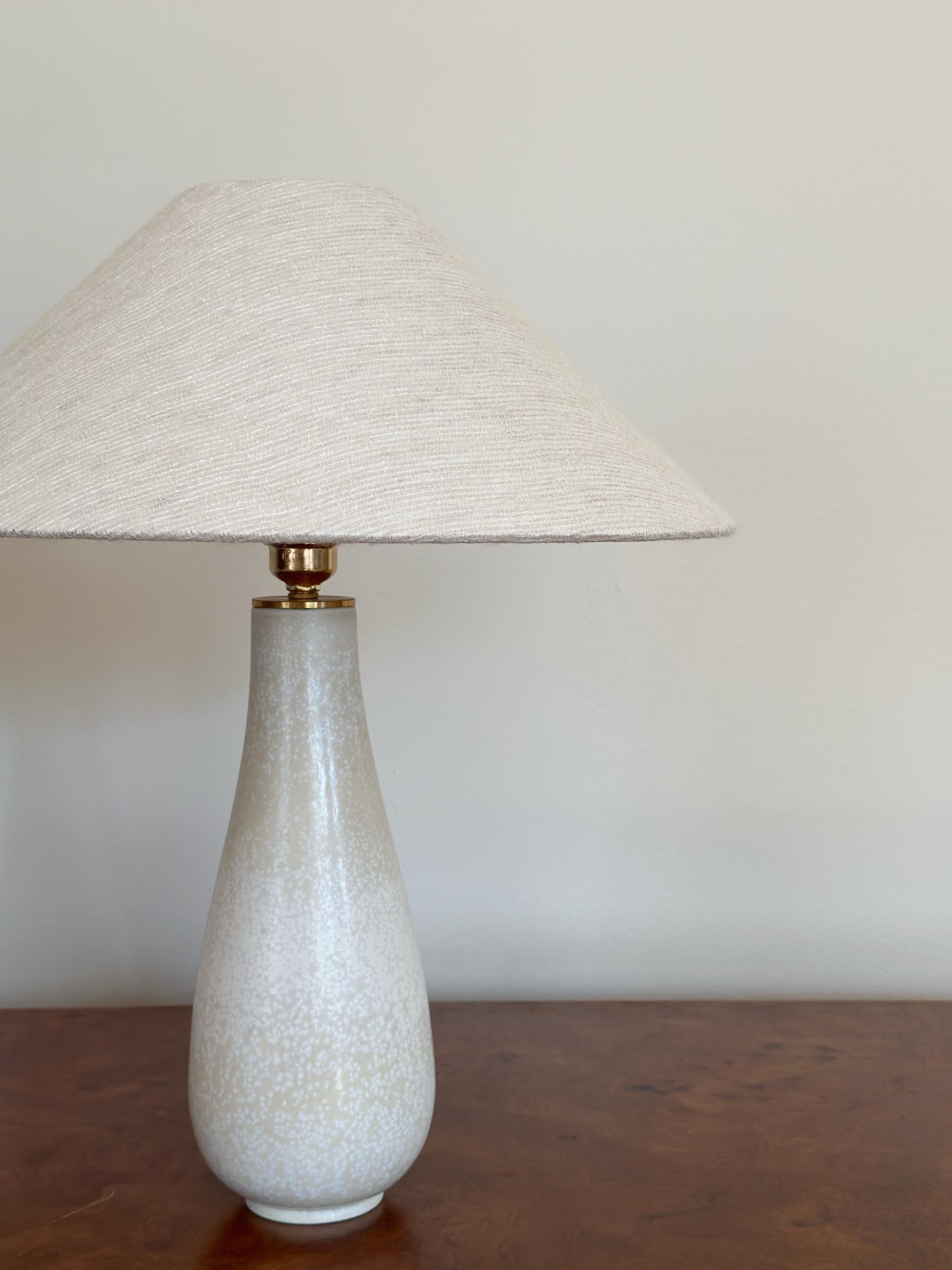Drop Formed Stoneware Table lamp by Gunnar Nylund for Rörstrand. Elegant, drawn shape with speckled pattern in creamy tones.
Made by Rörstrand, Sweden, 1940s. 
Inscribed R, 