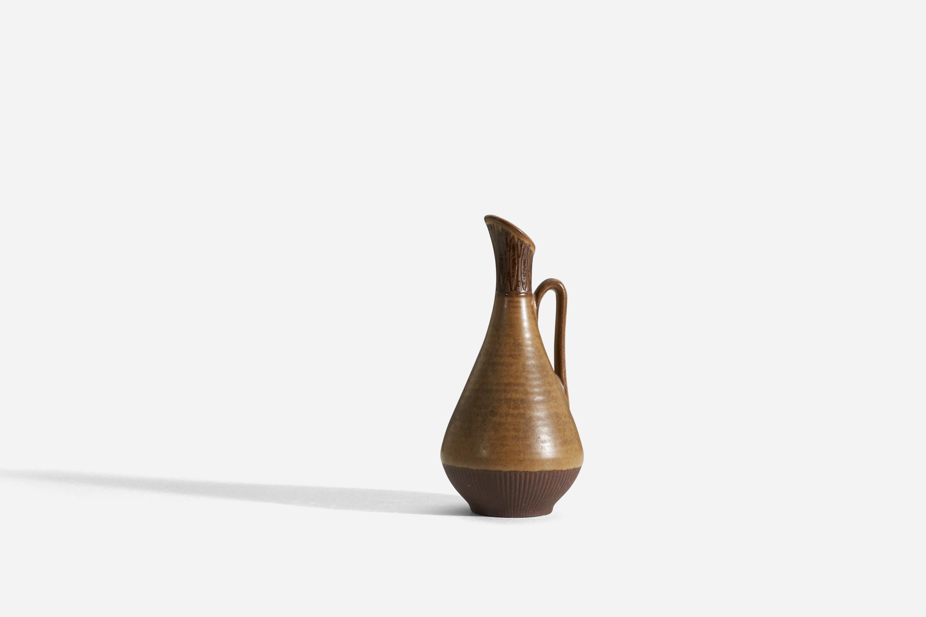 A sizable stoneware pitcher produced by Rörstrands, Sweden, 1940s. Designed and signed by Gunnar Nylund, (Swedish, 1914-1997).

Nylund served as artistic director at Rörstrands, where he worked 1931-1955. Prior to his work at Rörstrand he was a