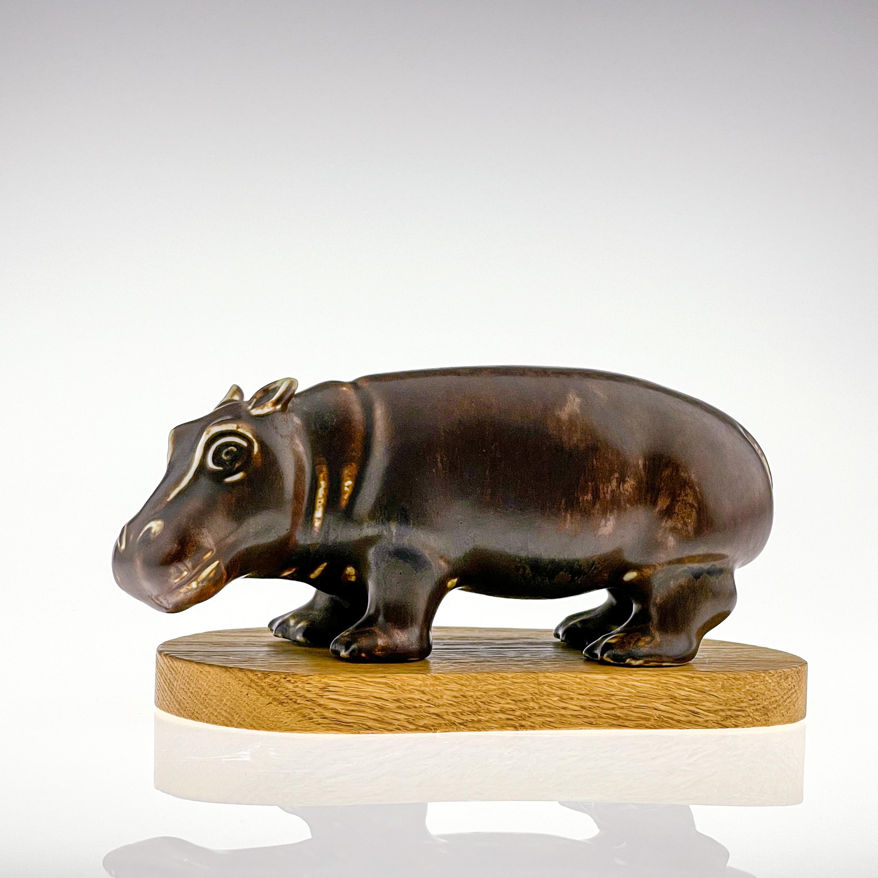 Gunnar Nylund, stoneware sculpture of a hippo, rörstrand, Sweden, circa 1955.

Description
A stoneware sculpture of an antilope, finished in several shades of brown glazes on the original wooden base. 

Gunnar Nyland was particular known for
