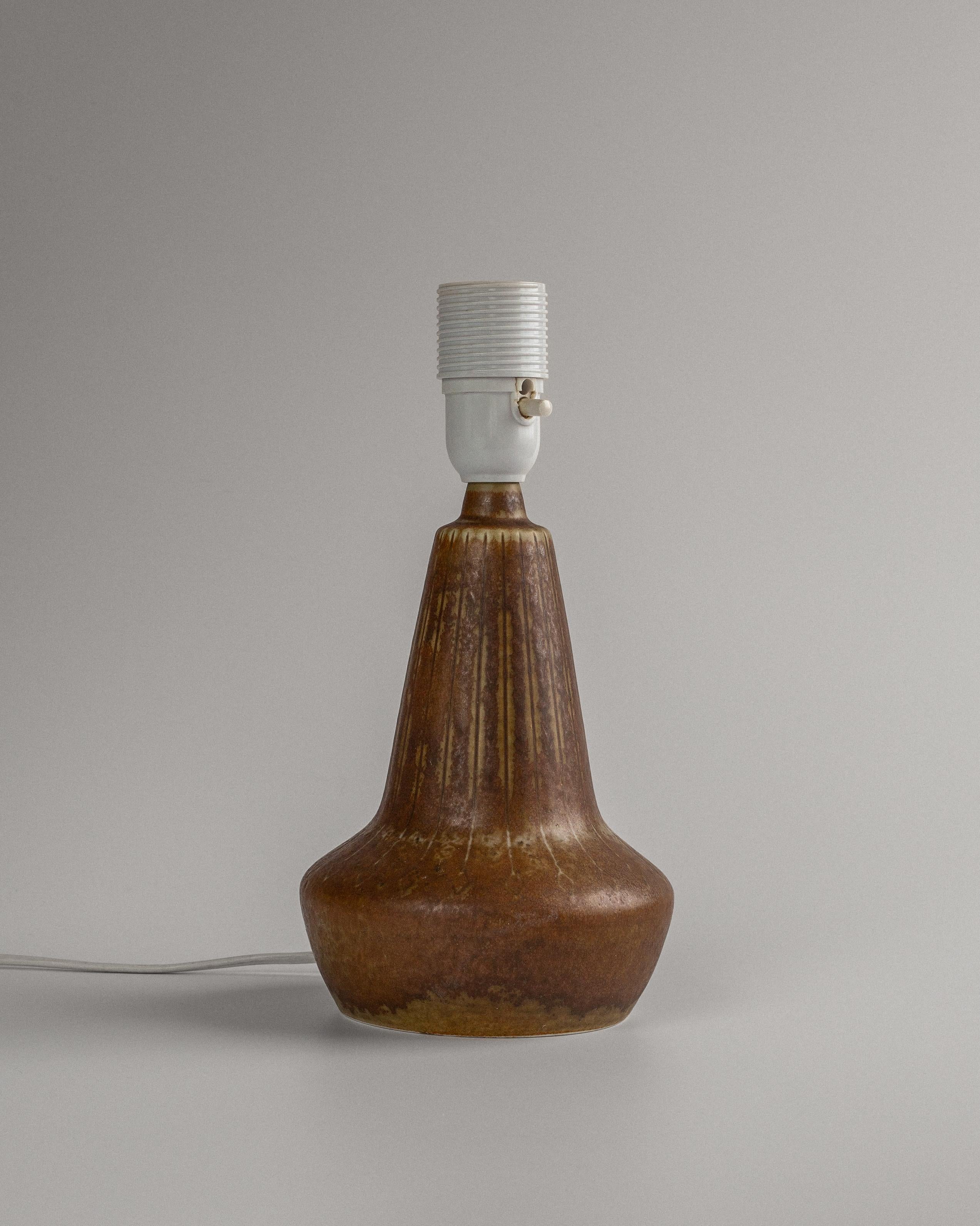 Kleine Tischlampe aus braun glasiertem Steingut, entworfen von Gunnar Nylund und hergestellt von Rörstrand, Schweden, 1960er Jahre. Abgewinkelte Form mit geschnitzten Nadelstreifen und Rautenmotiven und schöner, fließender brauner Glasur.