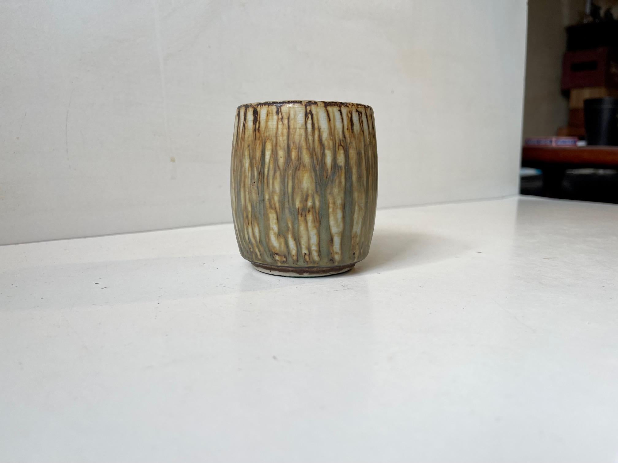 Piccolo vaso cilindrico con smalti Taupe, comunemente chiamati tigre. Disegnato da Gunnar Nylund e creato nel laboratorio di Rörstrand in Svezia negli anni '60. Completamente firmato e marcato. Misure: altezza: 8,5 cm, diametro: 7 cm (parte