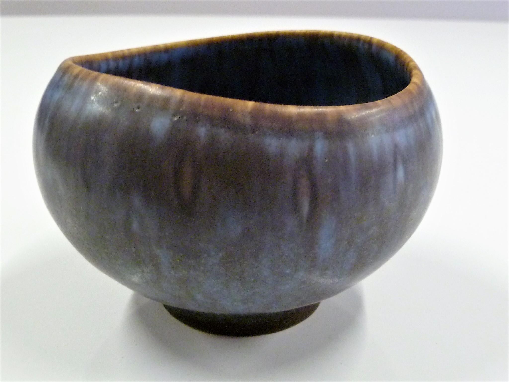 Scandinavian Modern stoneware petite pottery bowl by Gunnard Nylund for Rorstrand 1950s. Mottled glaze in blues, purple and brown, just beautiful. The vessel has no damages. The opening or mouth of bowl is elliptical rather than completely