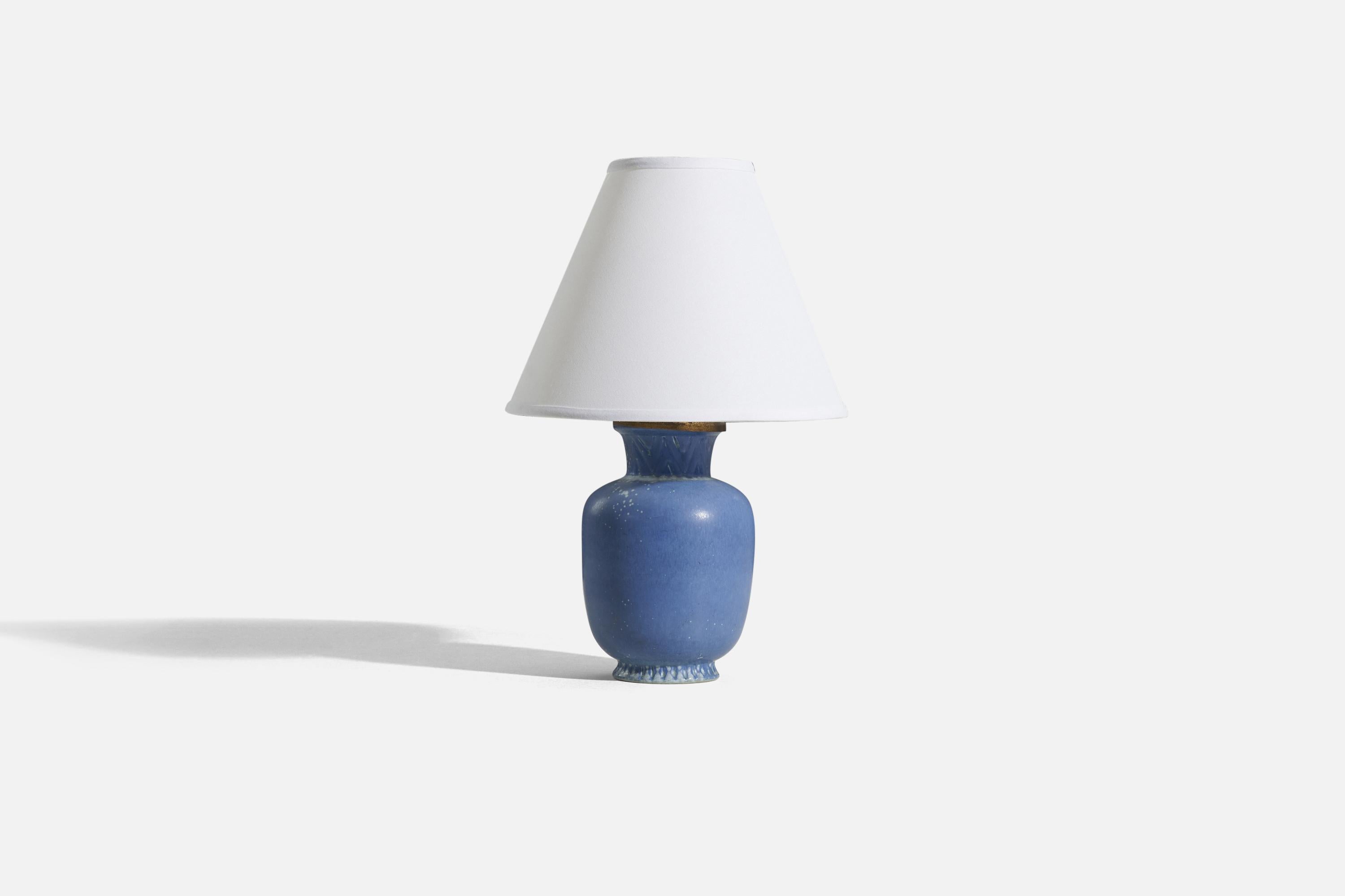 A blue-glazed stoneware and brass table lamp, designed by Gunnar Nylund and produced by Rörstrand, Sweden, 1950s.

Sold without lampshade. 
Dimensions of Lamp (inches) : 11.1875 x 5 x 5 (H x W x D)
Dimensions of Shade (inches) : 4 x 10 x 8 (T x