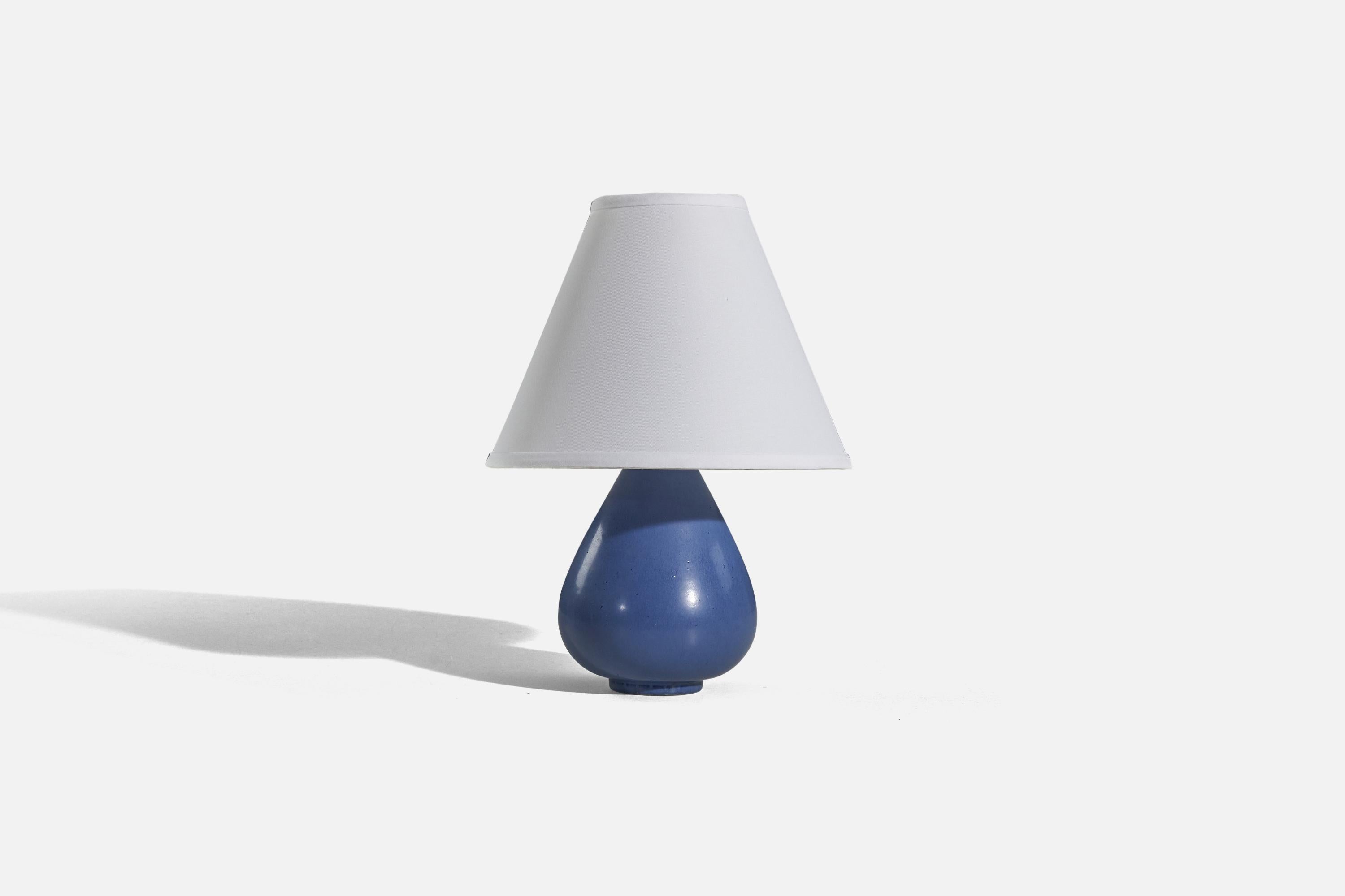 A blue, glazed stoneware table lamp designed by Gunnar Nylund and produced by Rörstrand, Sweden, 1950s. 

Sold without lampshade. 
Dimensions of lamp (inches) : 9.5 x 5.5 x 5.5 (H x W x D)
Dimensions of shade (inches) : 4.25 x 10.25 x 8 (T x B x