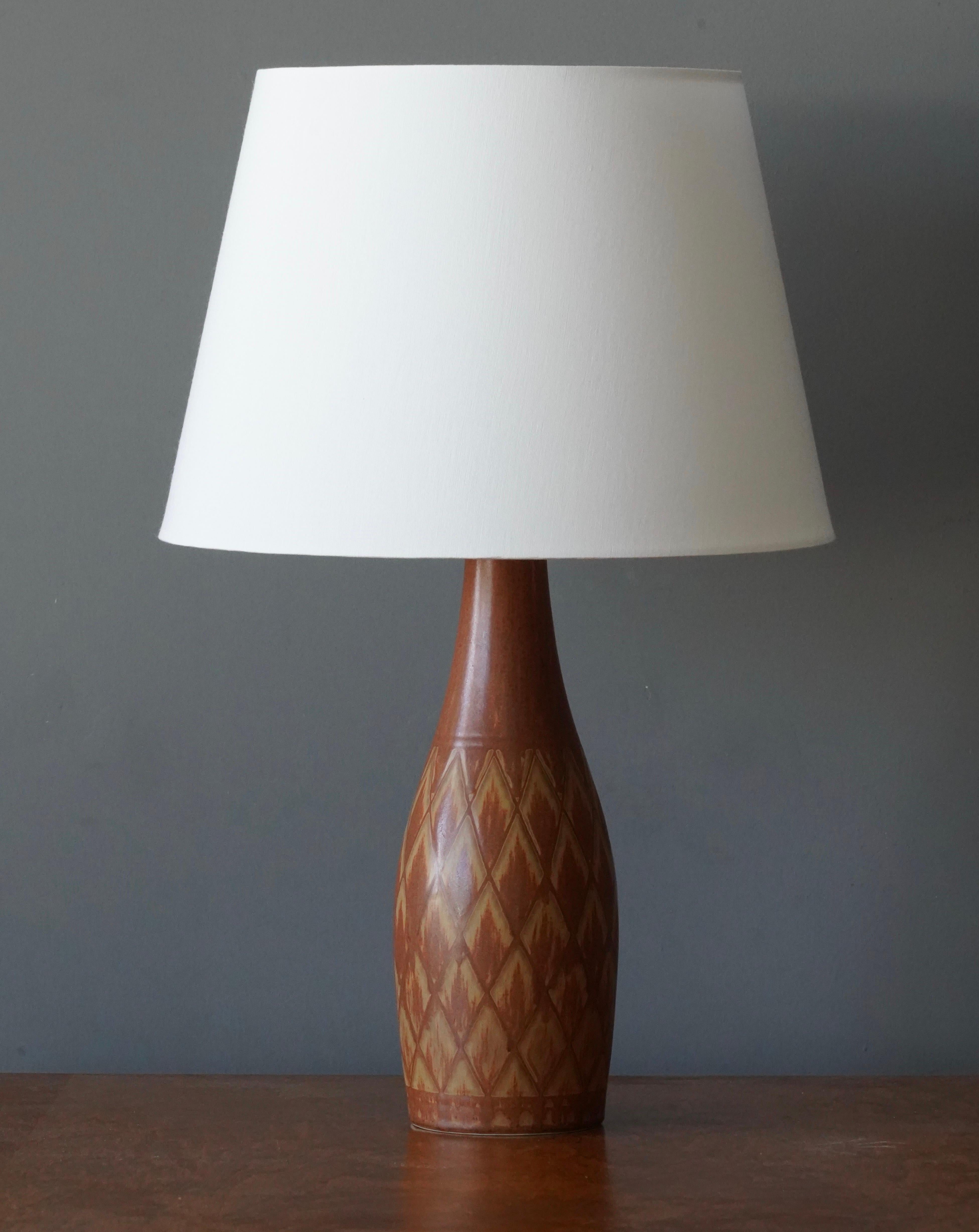 A table lamp produced by Rörstrand, Sweden, 1950s. Designed by Gunnar Nylund, (Swedish, 1914-1997). Signed. 

Sold without lampshade. Stated dimensions exclude lampshade, height includes socket.

Nylund served as artistic director at Rörstrand,