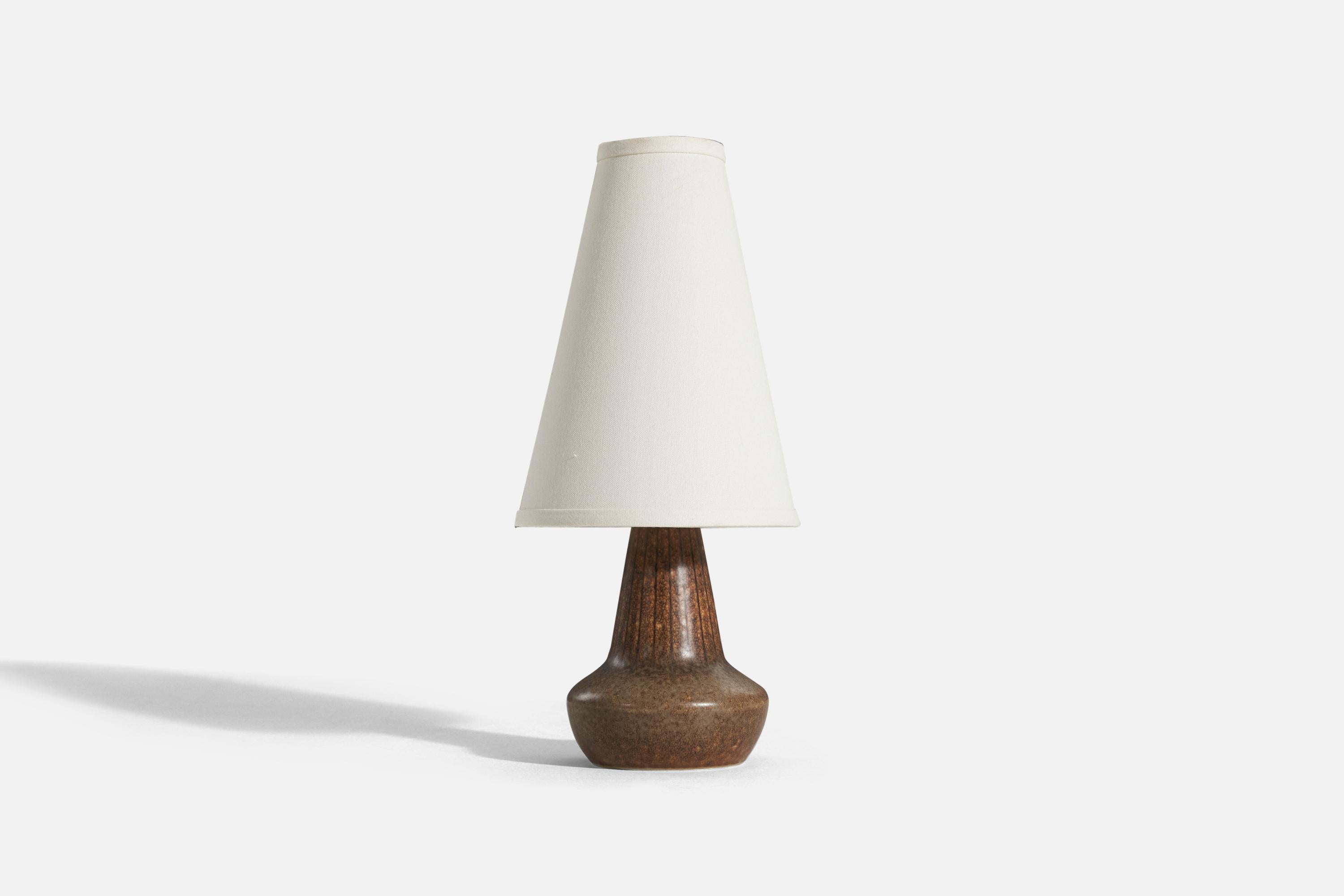 A brown, glazed stoneware table lamp designed by Gunnar Nylund and produced by Rörstrand, Sweden, 1950s.

Sold without lampshade. 
Dimensions of Lamp (inches) : 10.0625 x 5.3125 x 5.3125 (H x W x D)
Dimensions of Shade (inches) : 3.25 x 7.25 x