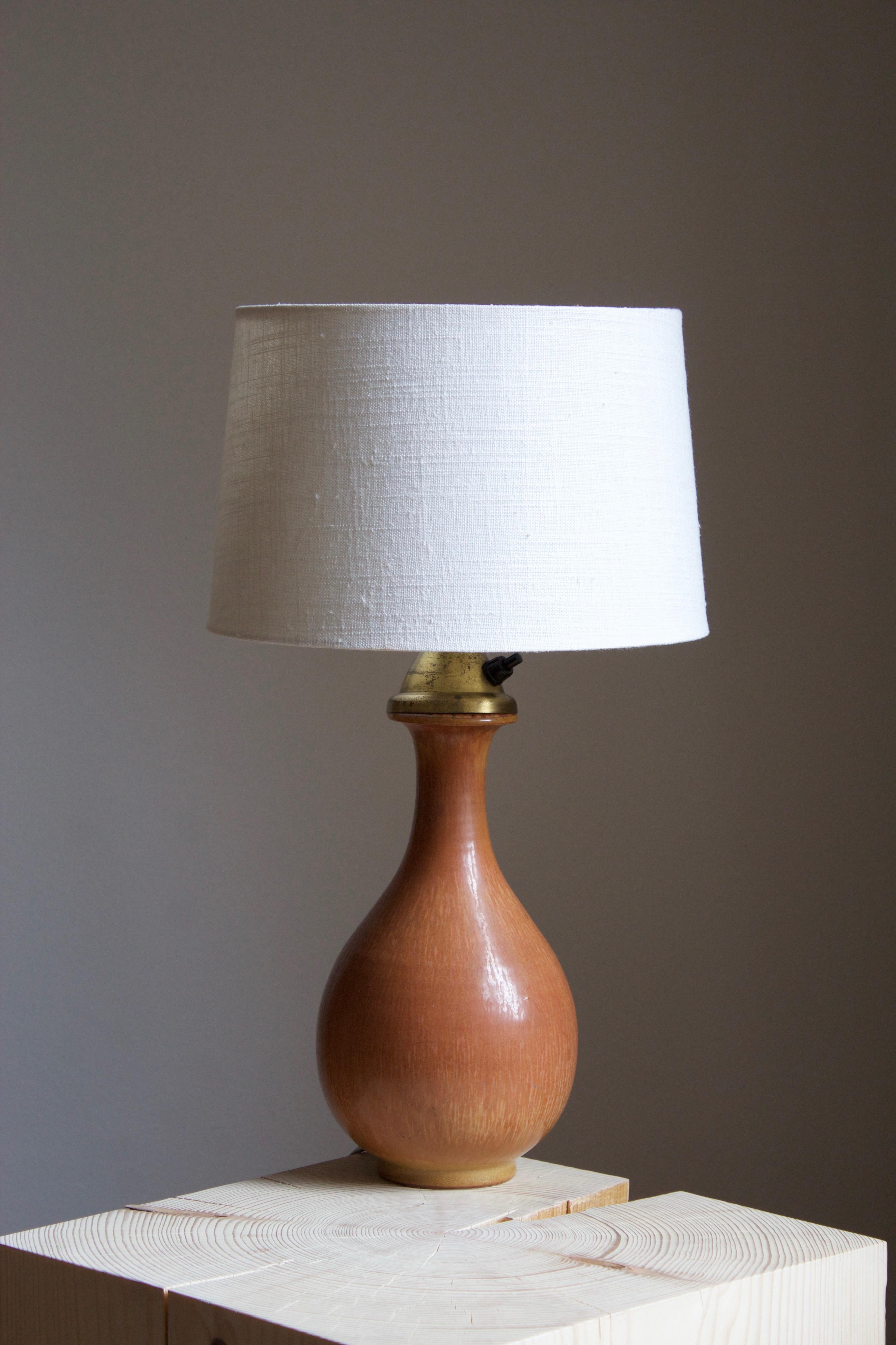A table lamp produced by Rörstrand, Sweden, 1950s. Designed by Gunnar Nylund, (Swedish, 1914-1997). Signed.

Sold without lampshade, stated dimensions exclude lampshade but includes socket.

Nylund served as artistic director at Rörstrand, where he