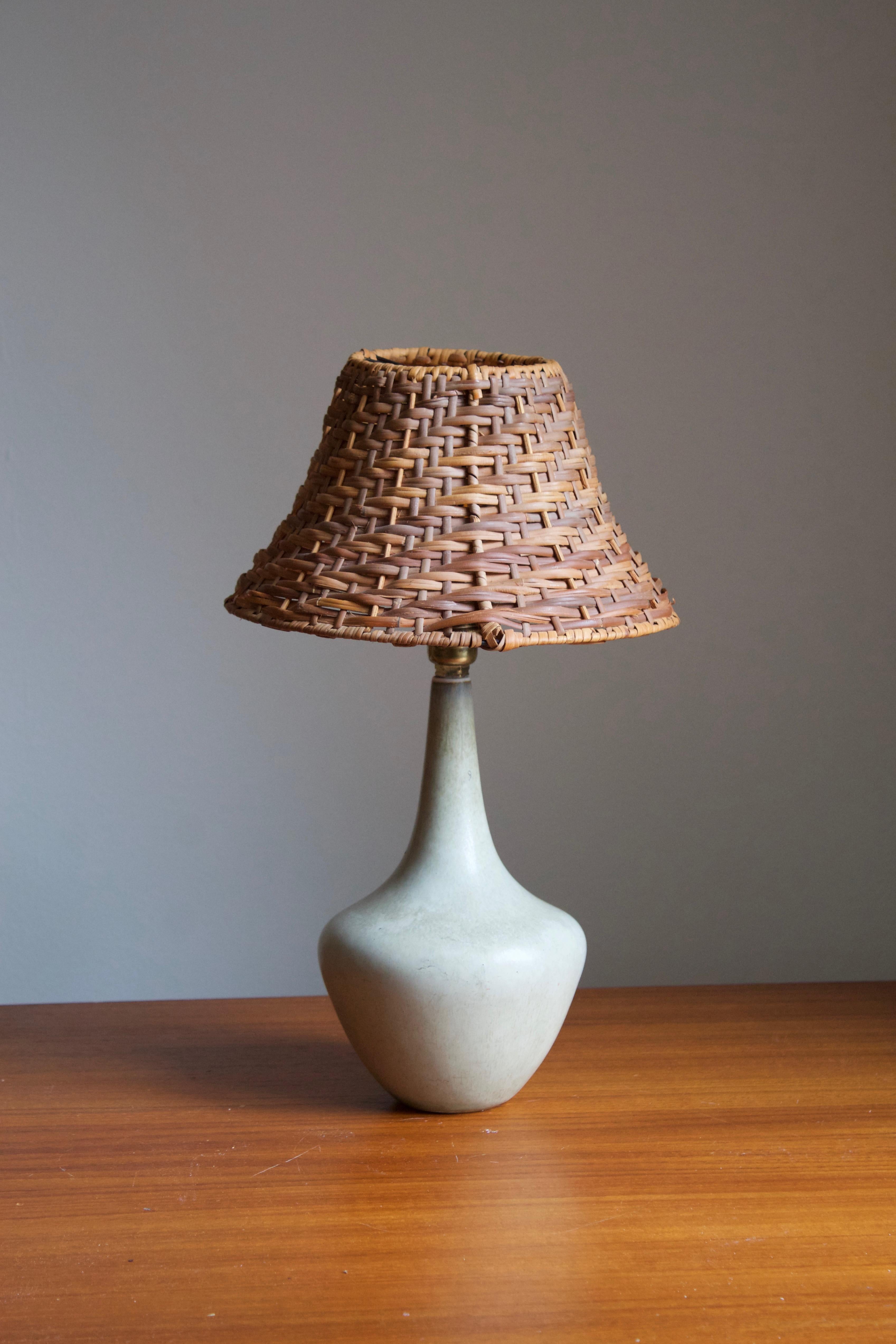 A table lamp produced by Rörstrand, Sweden, 1950s. Designed by Gunnar Nylund, (Swedish, 1914-1997). Signed. 

Stated dimensions exclude lampshade, height includes socket. Upon request, a vintage rattan lampshade of the illustrated model can be