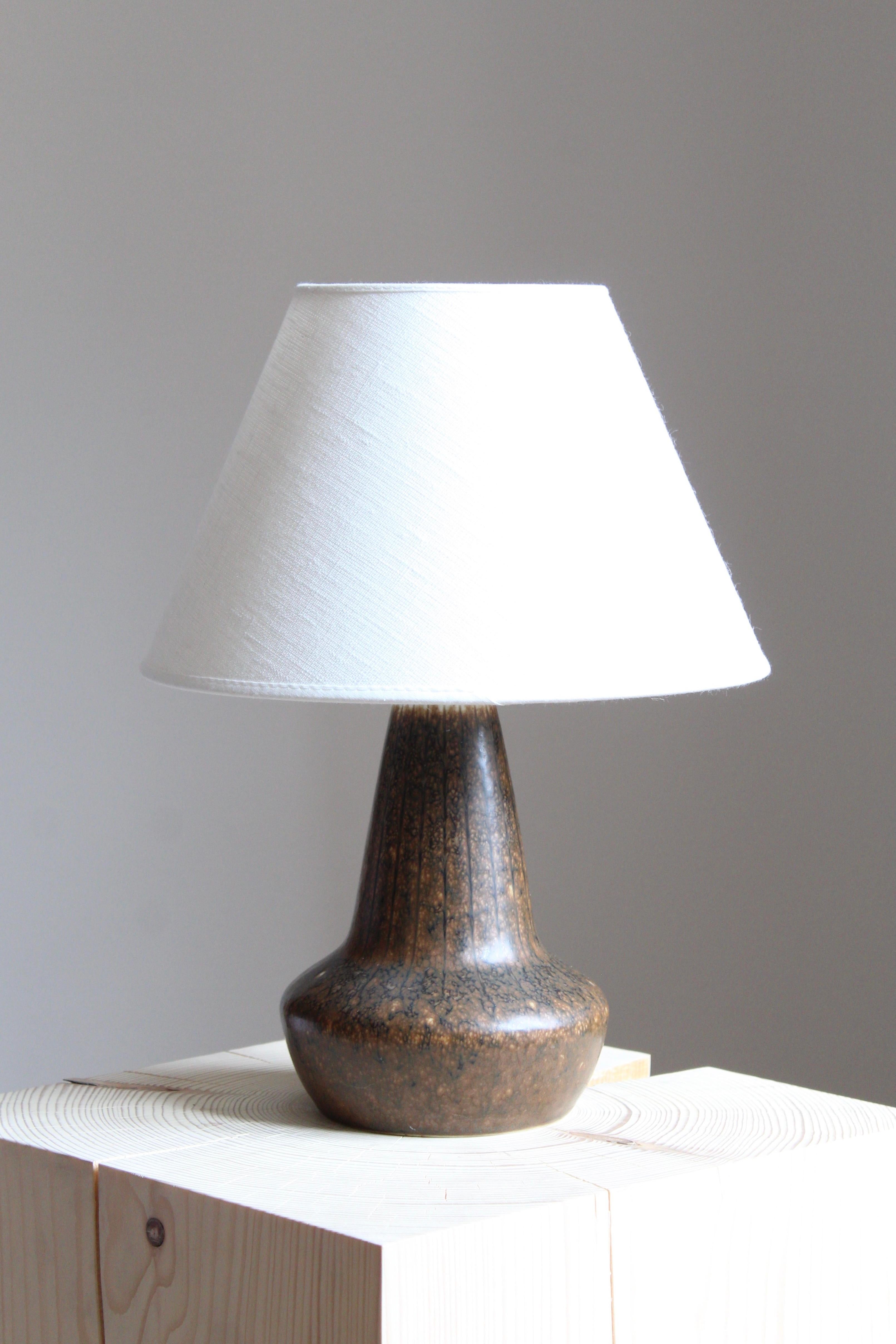 A table lamp produced by Rörstrand, Sweden, 1950s. Designed by Gunnar Nylund, (Swedish, 1914-1997). Signed. Shade not included.

Nylund served as artistic director at Rörstrand, where he worked, 1931-1955. Prior to his work at Rörstrand he was a
