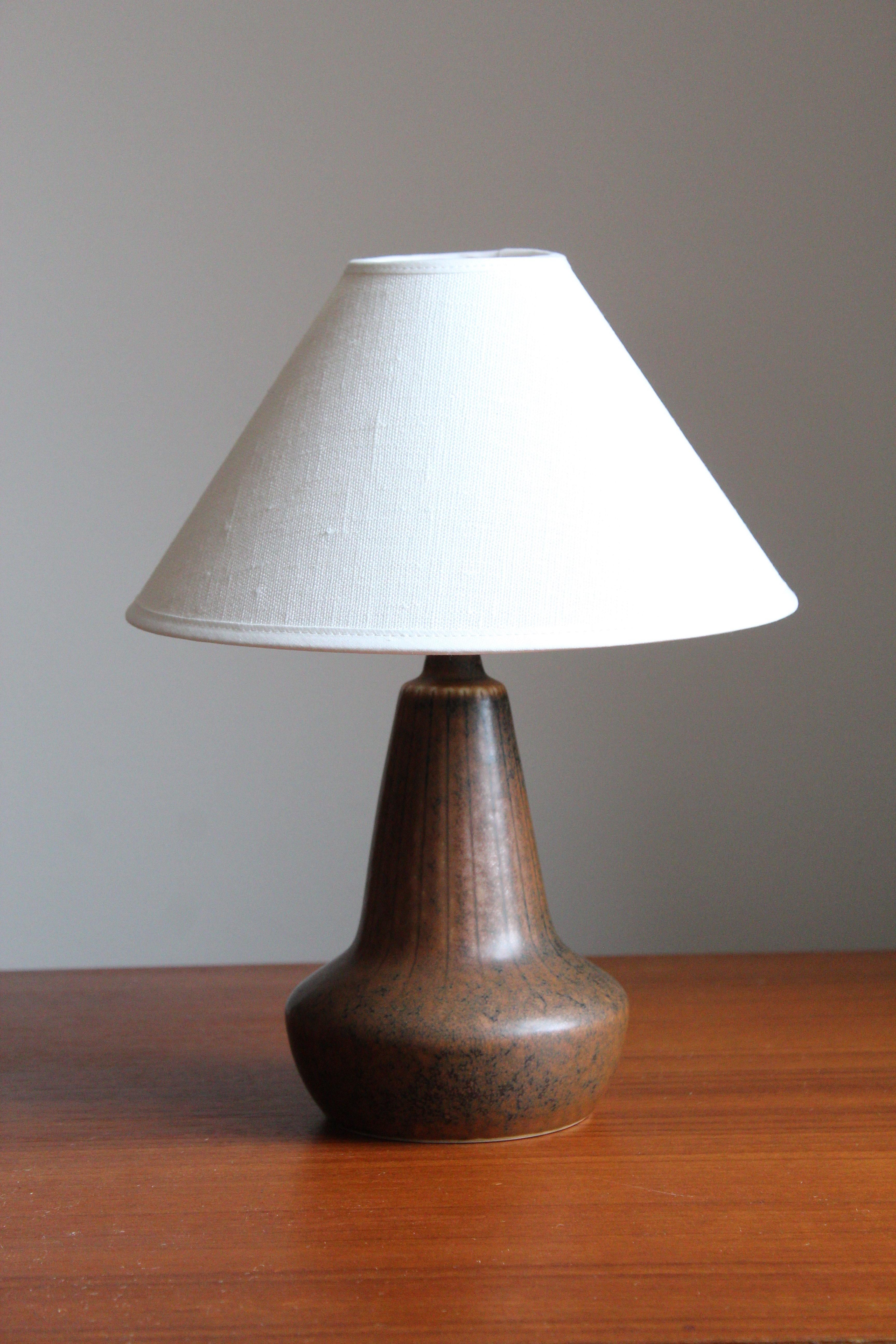A table lamp produced by Rörstrand, Sweden, 1950s. Designed by Gunnar Nylund, (Swedish, 1914-1997). Signed.

Sold without lampshade, stated dimensions exclude lampshade.

Nylund served as artistic director at Rörstrand, where he worked, 1931-1955.