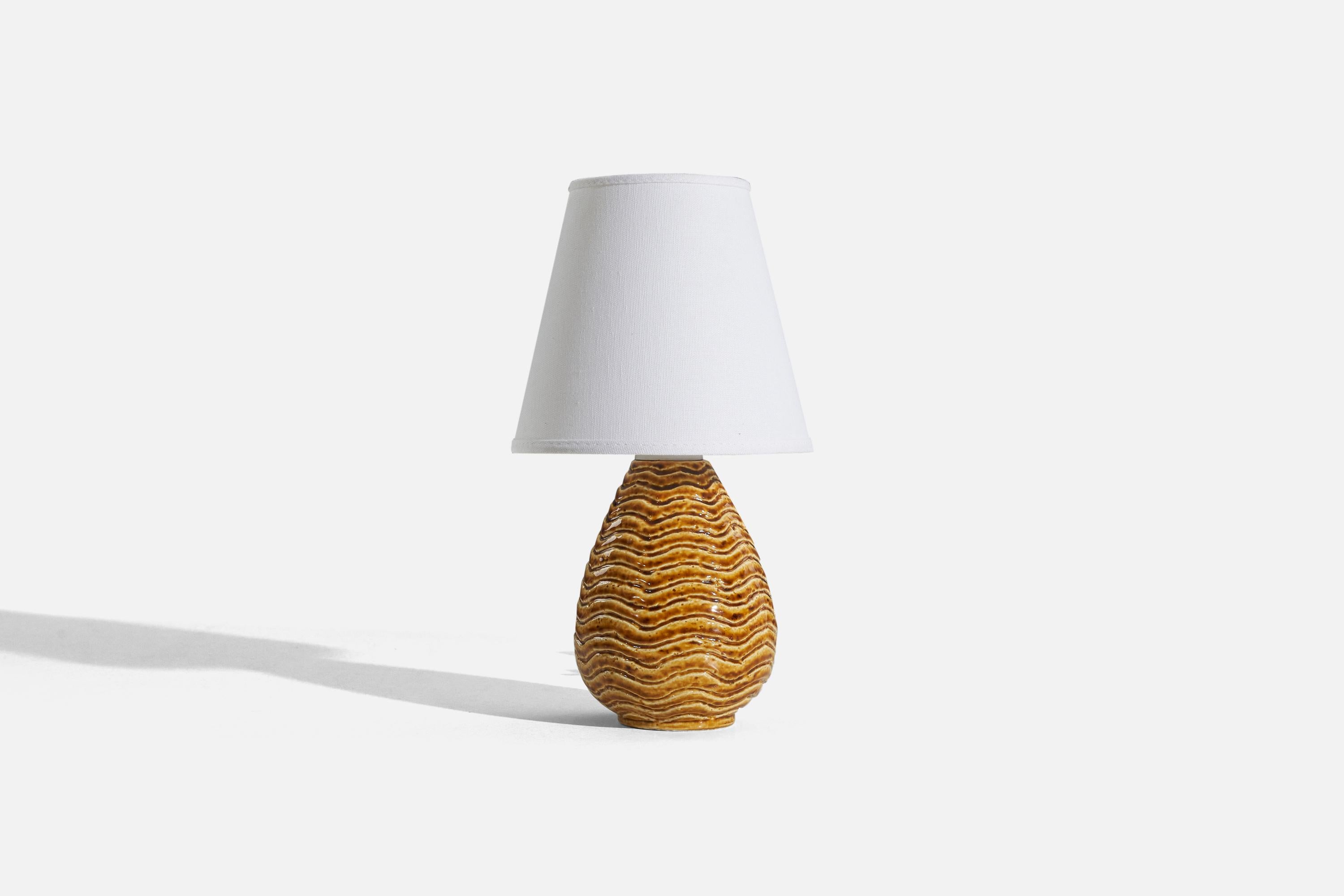 An orange, glazed stoneware table lamp designed by Gunnar Nylund and produced by Rörstrand, Sweden, 1940s. 

Sold without lampshade. 
Dimensions of Lamp (inches) : 8.5 x 5.625 x 5.625 (H x W x D)
Dimensions of Shade (inches) : 4.0625 x 6.75 x