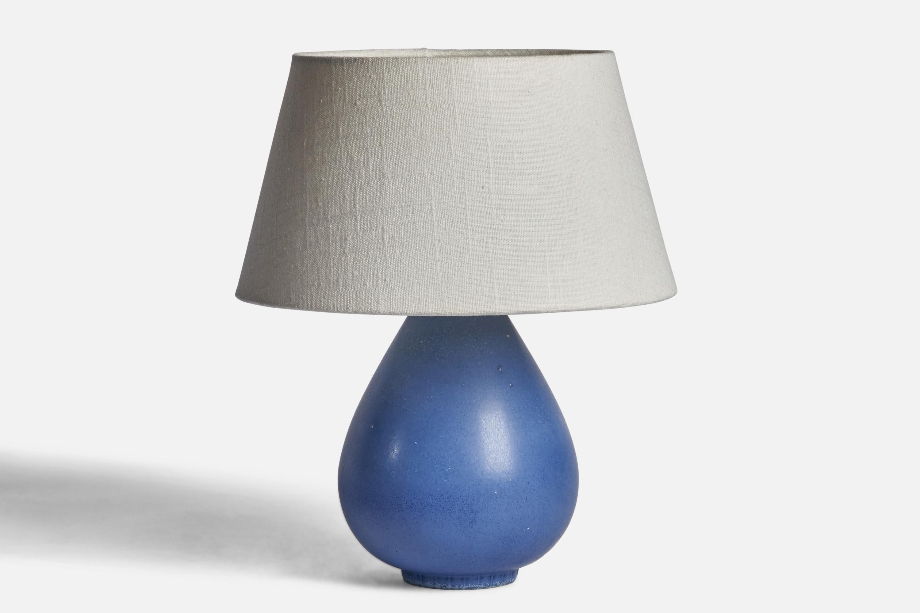 A blue-glazed stoneware table lamp designed by Gunnar Nylund and produced by Rörstrand, Sweden, 1940s.

Dimensions of Lamp (inches): 9” H x 5.25” Diameter
Dimensions of Shade (inches): 7” Top Diameter x 10” Bottom Diameter x 5.5” H 
Dimensions of