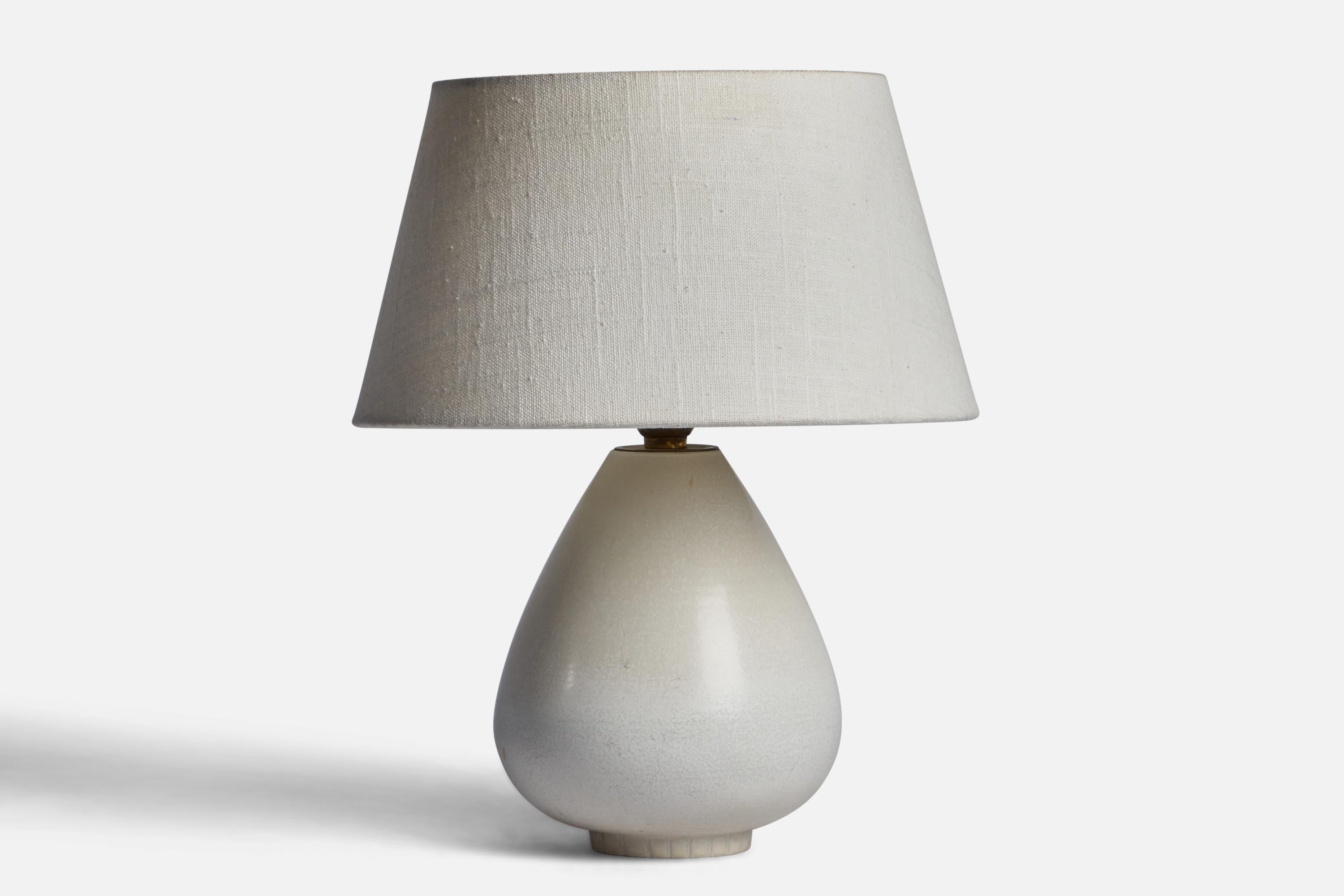 An off-white-glazed stoneware table lamp designed by Gunnar Nylund and produced by Rörstrand, Sweden, 1940s.

Dimensions of Lamp (inches): 9.25” H x 6” Diameter
Dimensions of Shade (inches): 7” Top Diameter x 10” Bottom Diameter x 5.5” H 
Dimensions