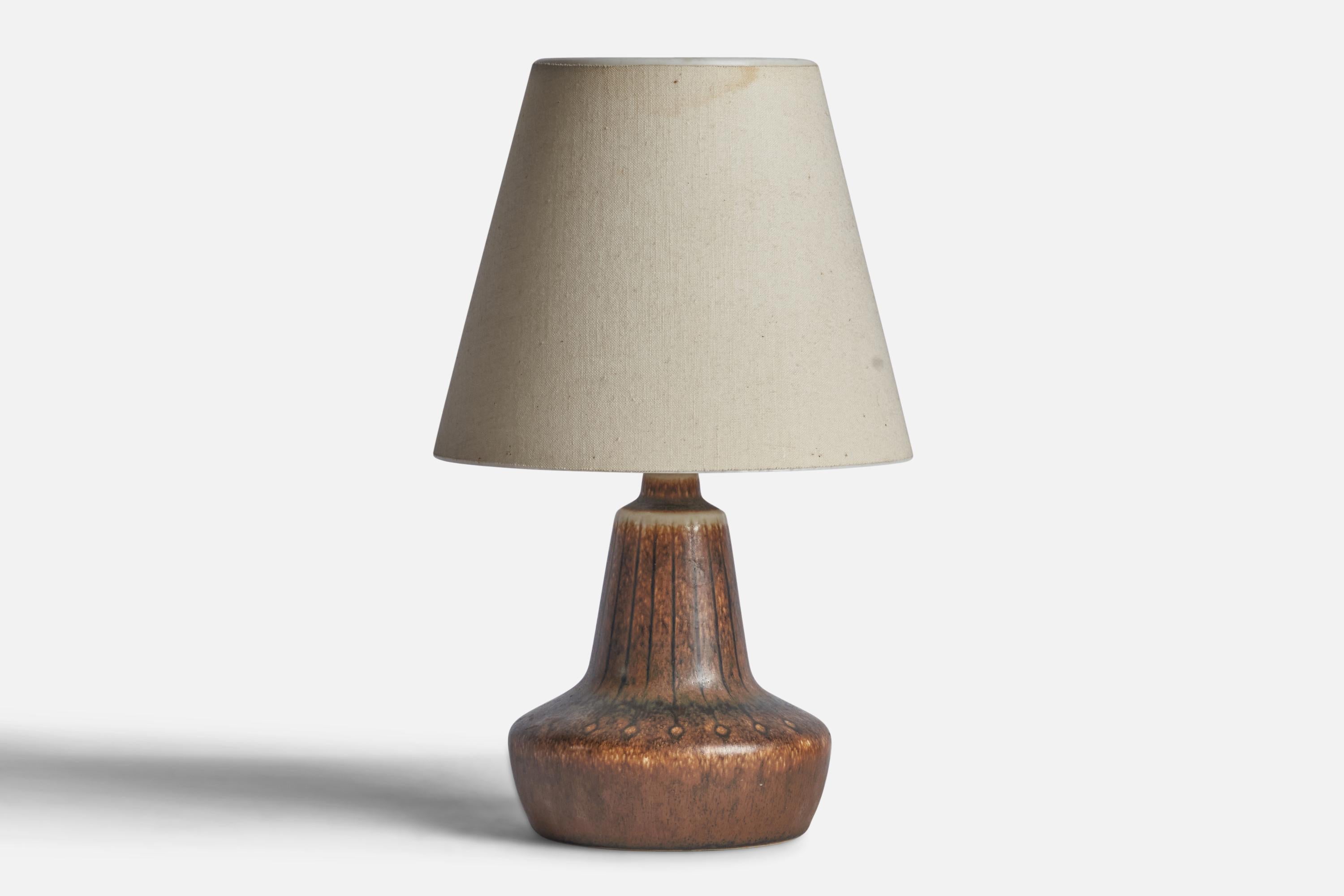A brown-glazed incised stoneware table lamp designed by Gunnar Nylund and produced by Rörstrand, Sweden, c. 1940s.

“SWEDEN 669” stamp on bottom
Dimensions of Lamp (inches): 7.25” H x 4.5” Diameter
Dimensions of Shade (inches): 3.5” Top Diameter x