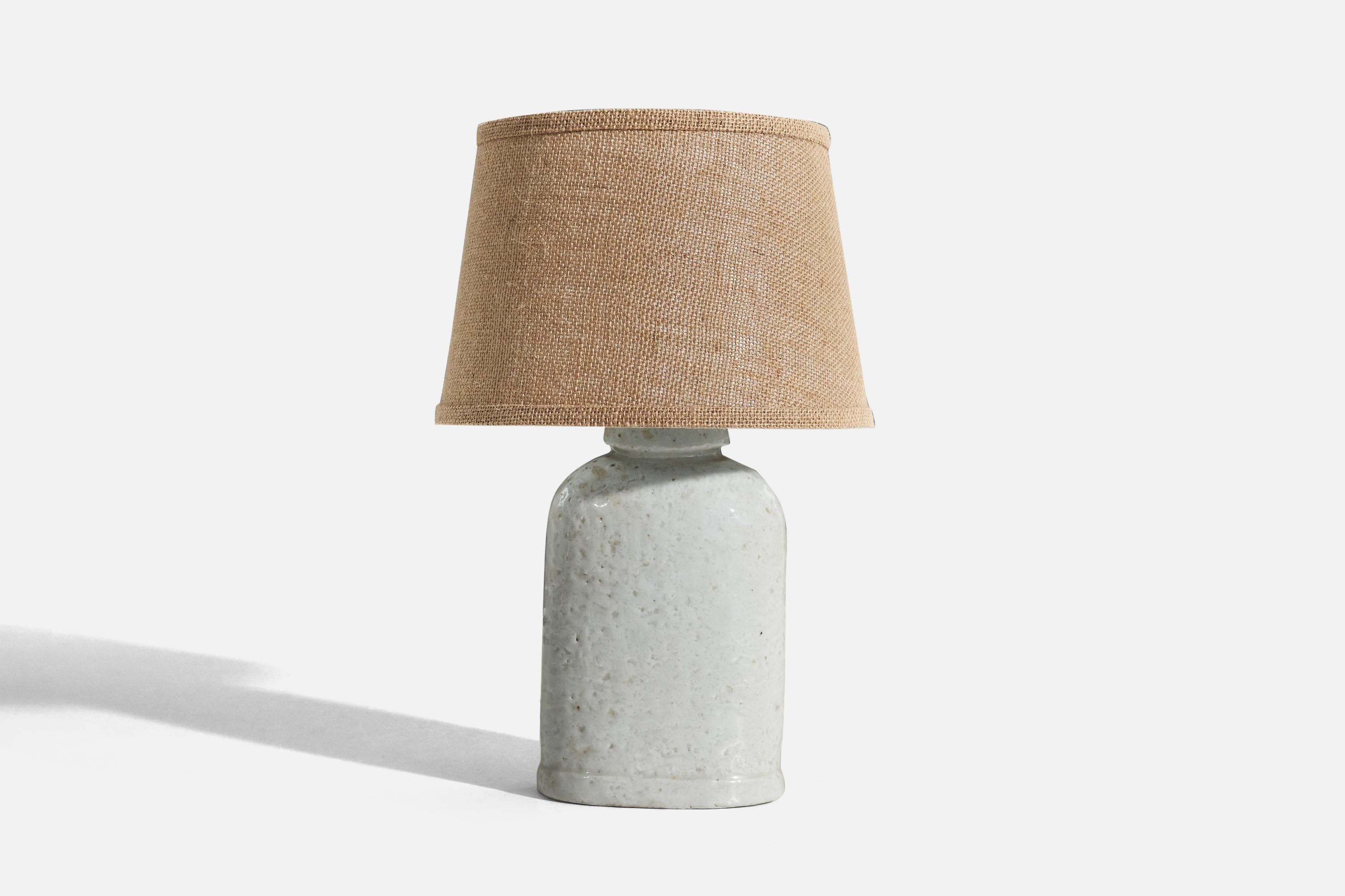 A white, glazed stoneware table lamp designed by Gunnar Nylund and produced by Rörstrand, Sweden, 1950s. 

Sold without lampshade. 
Dimensions of Lamp (inches) : 12.12 x 5.87 x 3.5 (H x W x D)
Dimensions of Shade (inches) : 8 x 10.25 x 7 (T x B