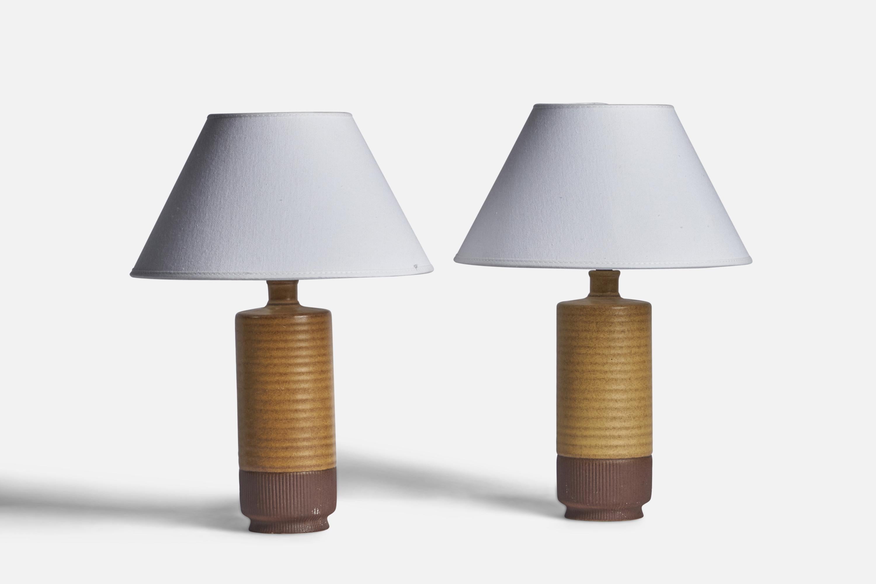 A pair of yellow beige and brown-glazed stoneware table lamps designed by Gunnar Nylund and produced by Rörstrand, Sweden, 1940s.

Dimensions of Lamp (inches): 10.5” H x 3.2” Diameter
Dimensions of Shade (inches): 4.5” Top Diameter x 10” Bottom