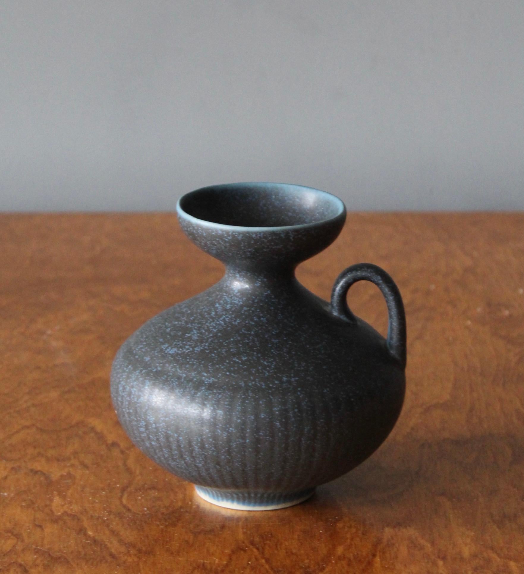 A vase or vessel produced by Rörstrands, Sweden, 1950s. Designed by Gunnar Nylund, (Swedish, 1914-1997). Signed.

Nylund served as artistic director at Rörstrands, where he worked 1931-1955. Prior to his work at Rörstrand he was a well-established