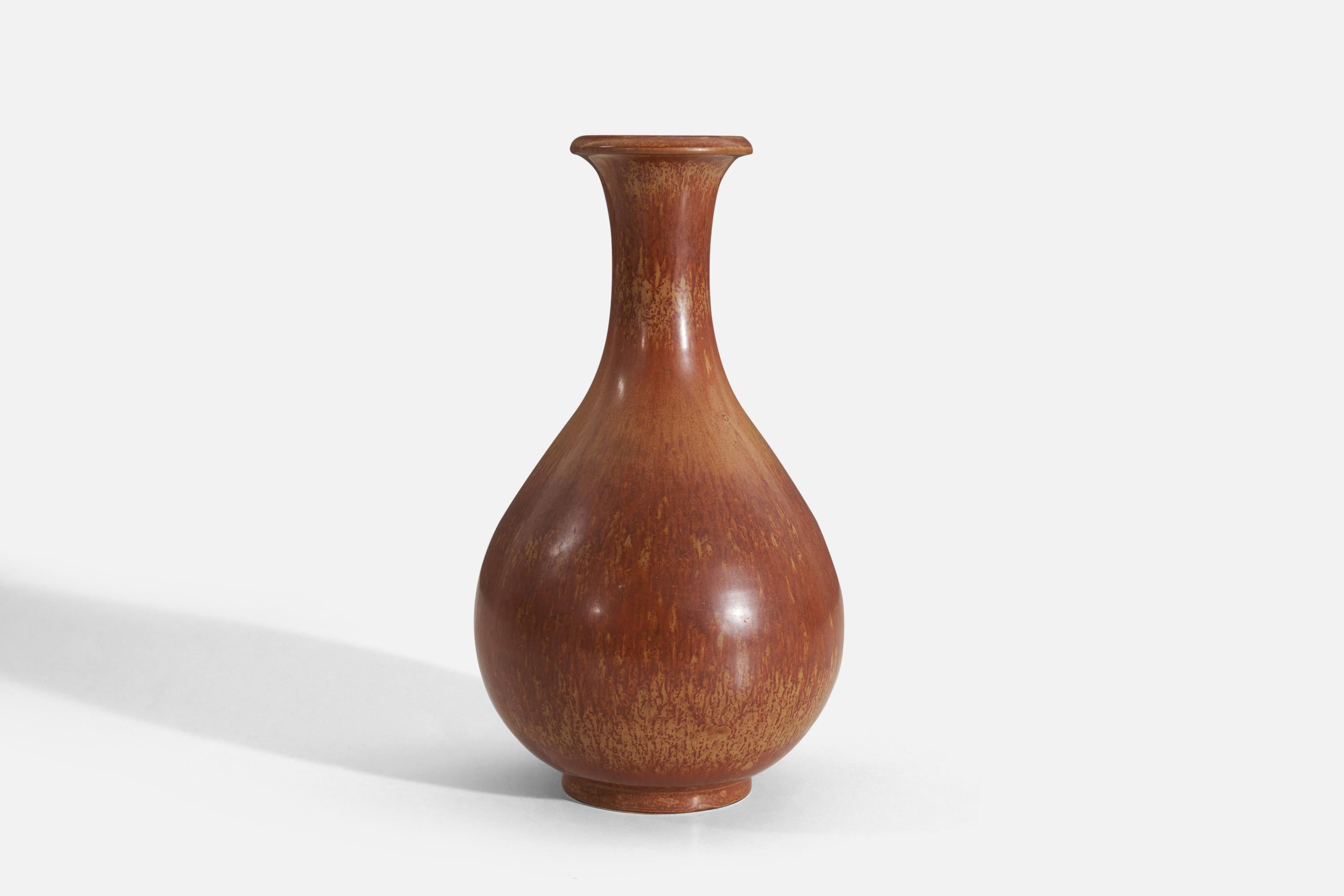 Un vase en grès émaillé orange / jaune / brun conçu par Gunnar Nylund (suédois, 1914-1997) et produit par Rörstrand, Suède, années 1940. 

Nylund a été directeur artistique à Rörstrand, où il a travaillé de 1931 à 1955.