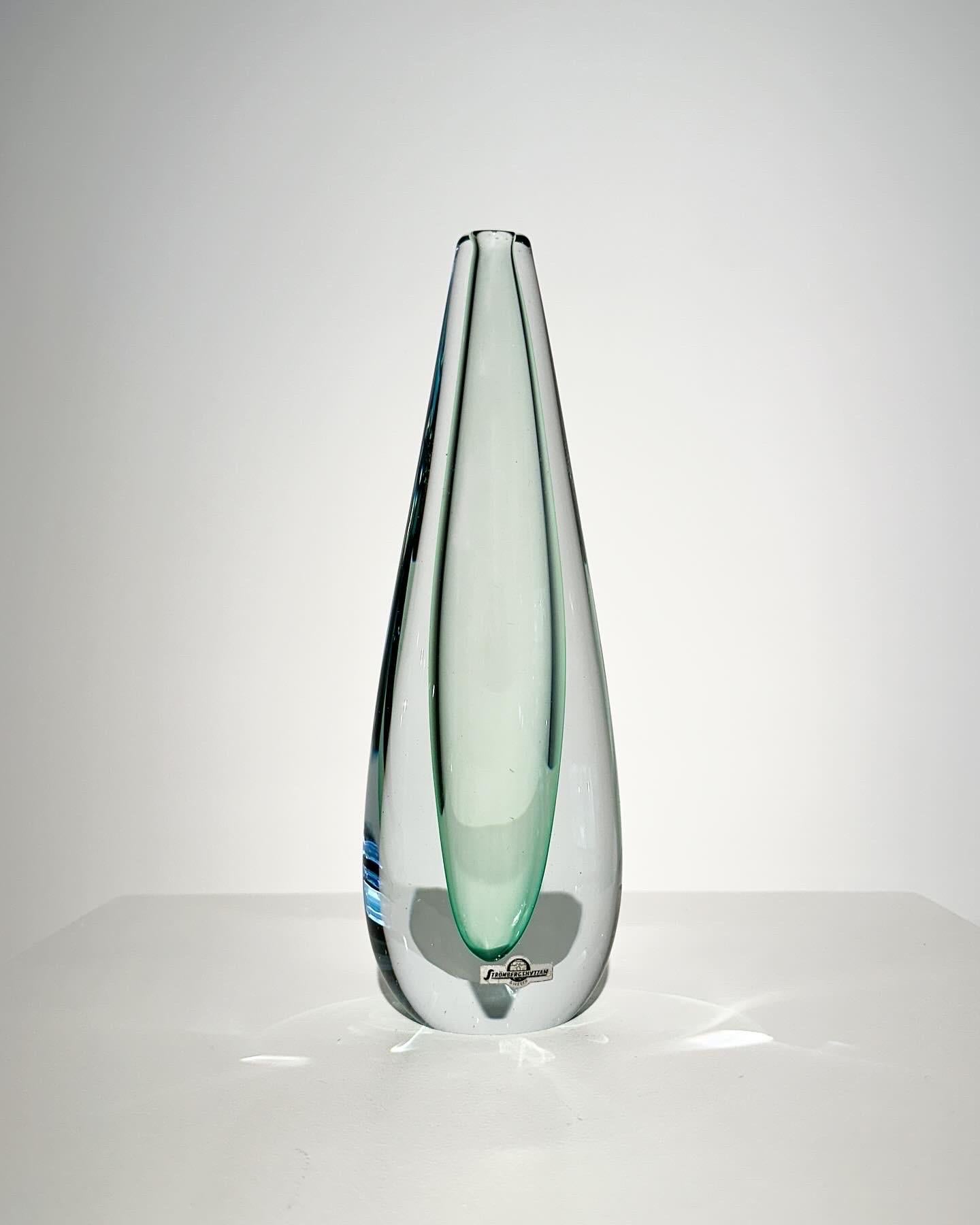 Vaso di Gunnar Nylund in vetro cristallo, per la vetreria Strömbergshyttan negli anni Sessanta.

Cristallo trasparente soffiato a bocca e modellato a mano con un sottile sottofondo verde turchese.

Altezza: 25.5 cm
Larghezza: 8.5 cm
Profondità: 5