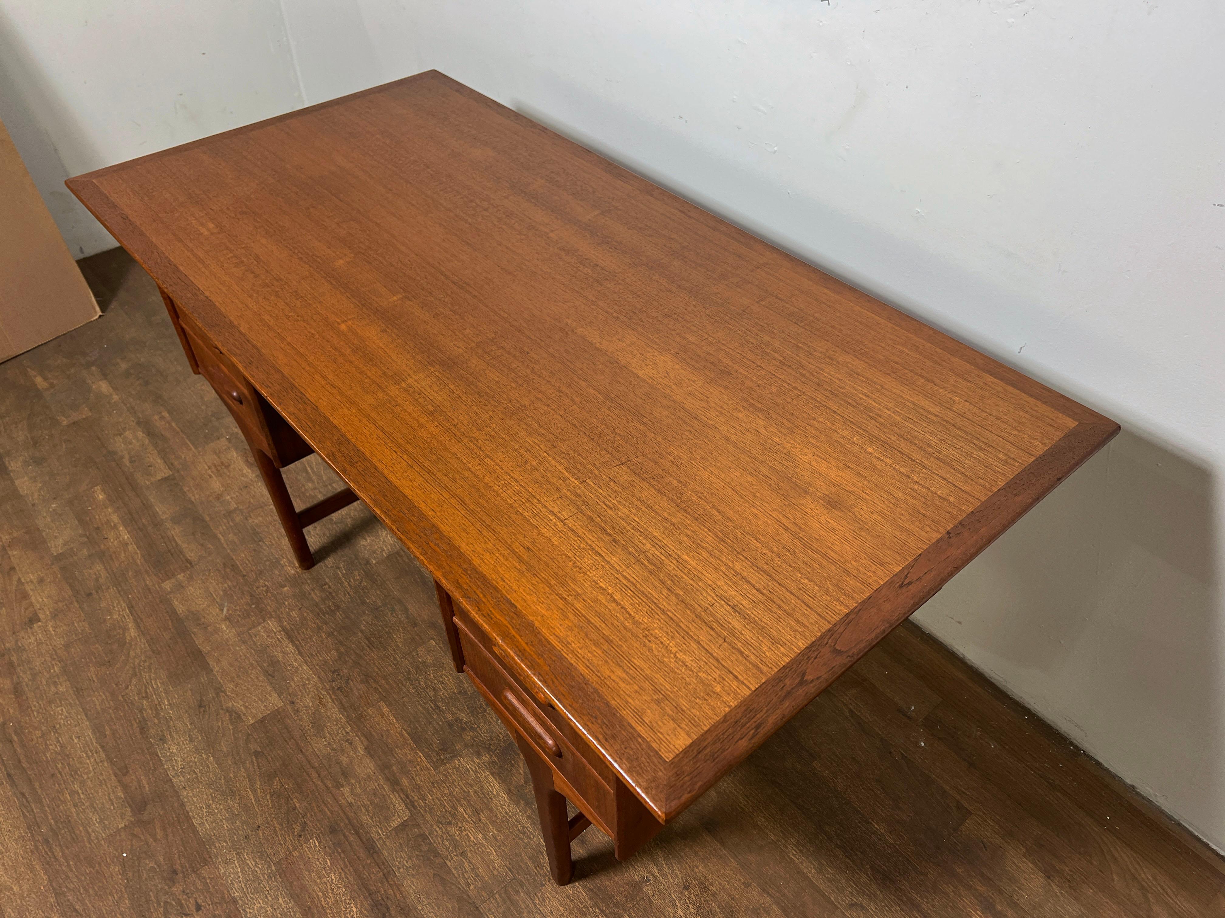 Classic teak desk, made in Denmark circa 1960s by Gunnar Tibergaard-Nielsen . Features a book shelf on reverse.