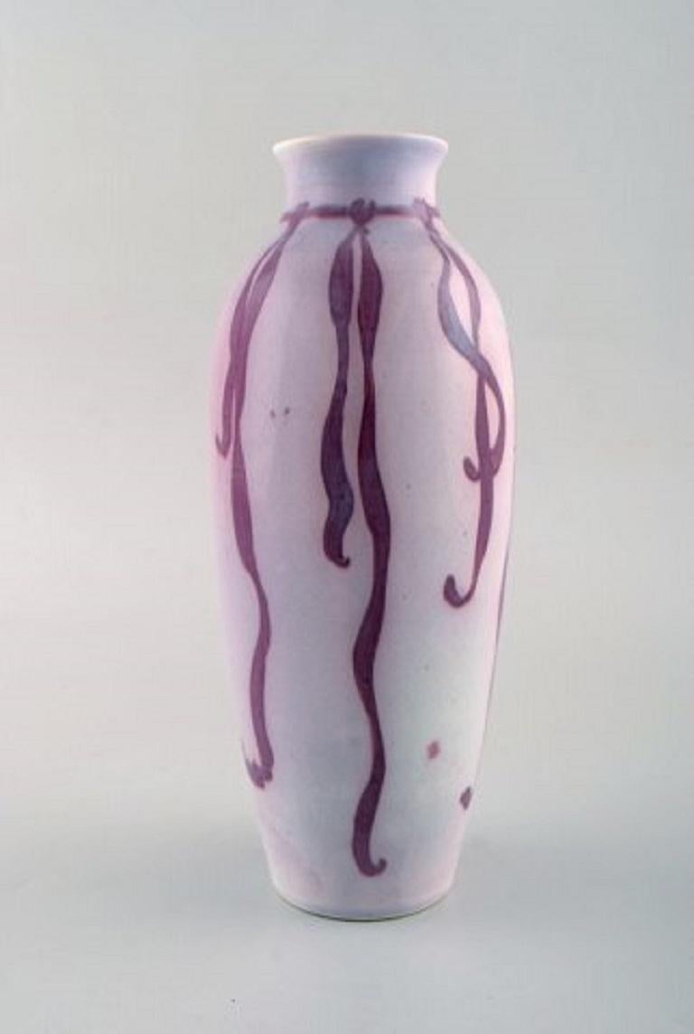 Gunnar Wennerberg for Gustafsberg. Unique Art Nouveau vase in glazed ceramics. Purple ribbon on pink background, circa 1900.
Measures: 22 x 9 cm.
Signed.
In very good condition.

  