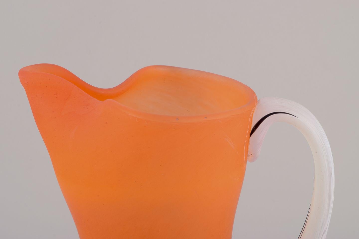 Suédois Gunnel Sahlin, Kosta Boda. Grande cruche en verre orange avec anse blanche. en vente