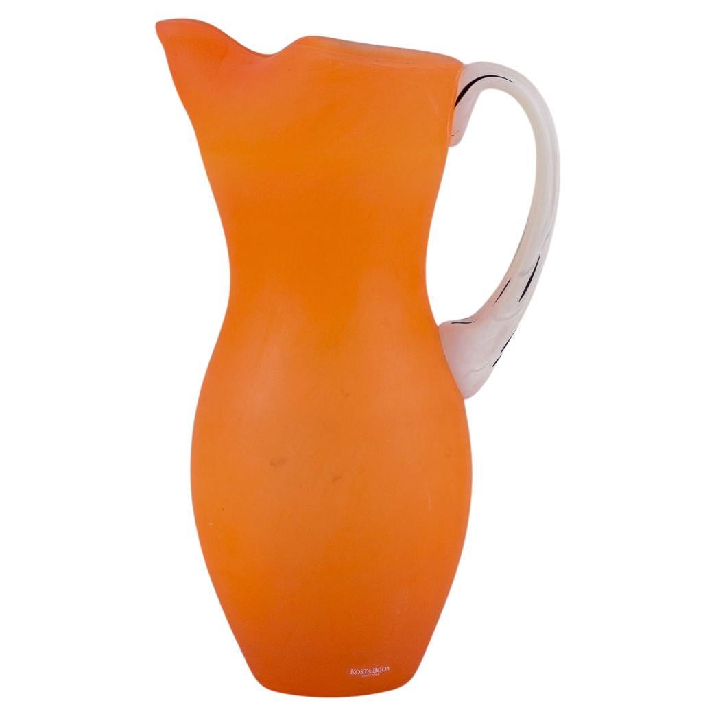 Gunnel Sahlin, Kosta Boda. Grande cruche en verre orange avec anse blanche. en vente