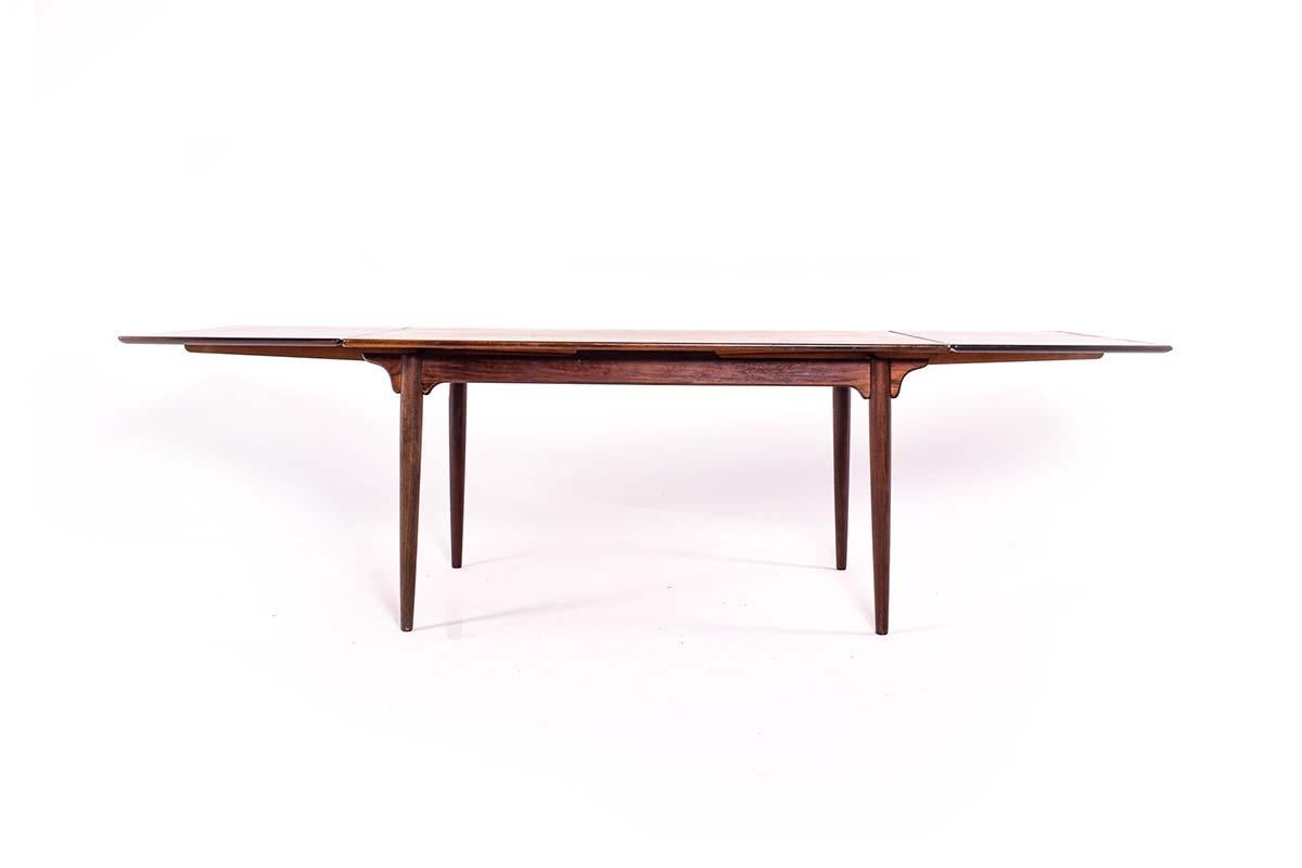 Midcentury Modern Omann Jun Møbelfabrik dining table in rosewood 1960, Denmark, designed by Gunni Omann Jr, with two extension leaves. This beautiful Model 54 table has a veneered rectangular rosewood top and edged in solid rosewood. When fully