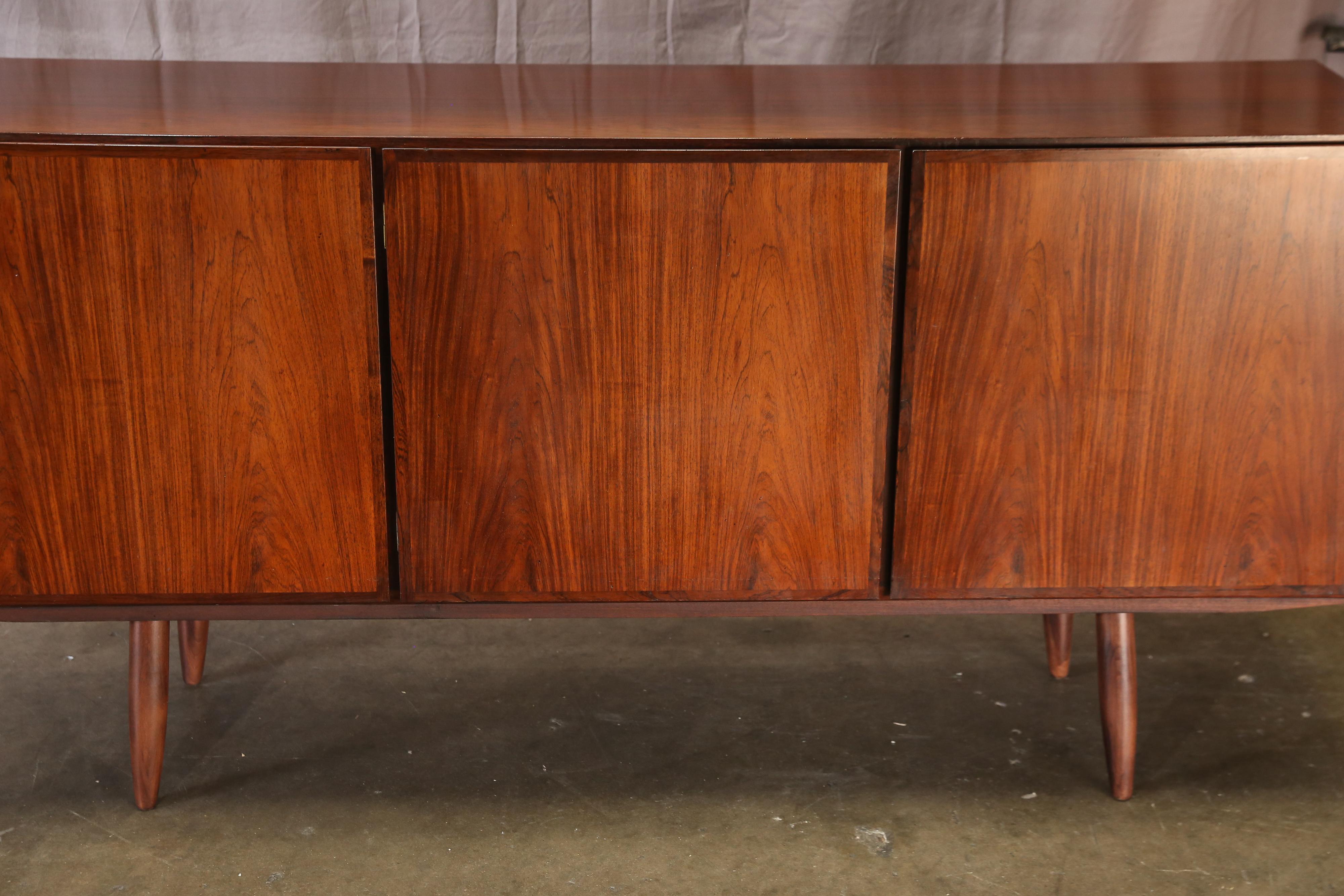 A finely-grained rosewood Model 30 credenza by Danish midcentury designer Gunni Omann for Omann Jun. Upper drawer and adjustable shelf in the left compartment. Double adjustable shelves in the centre and right compartments. Excellent condition.