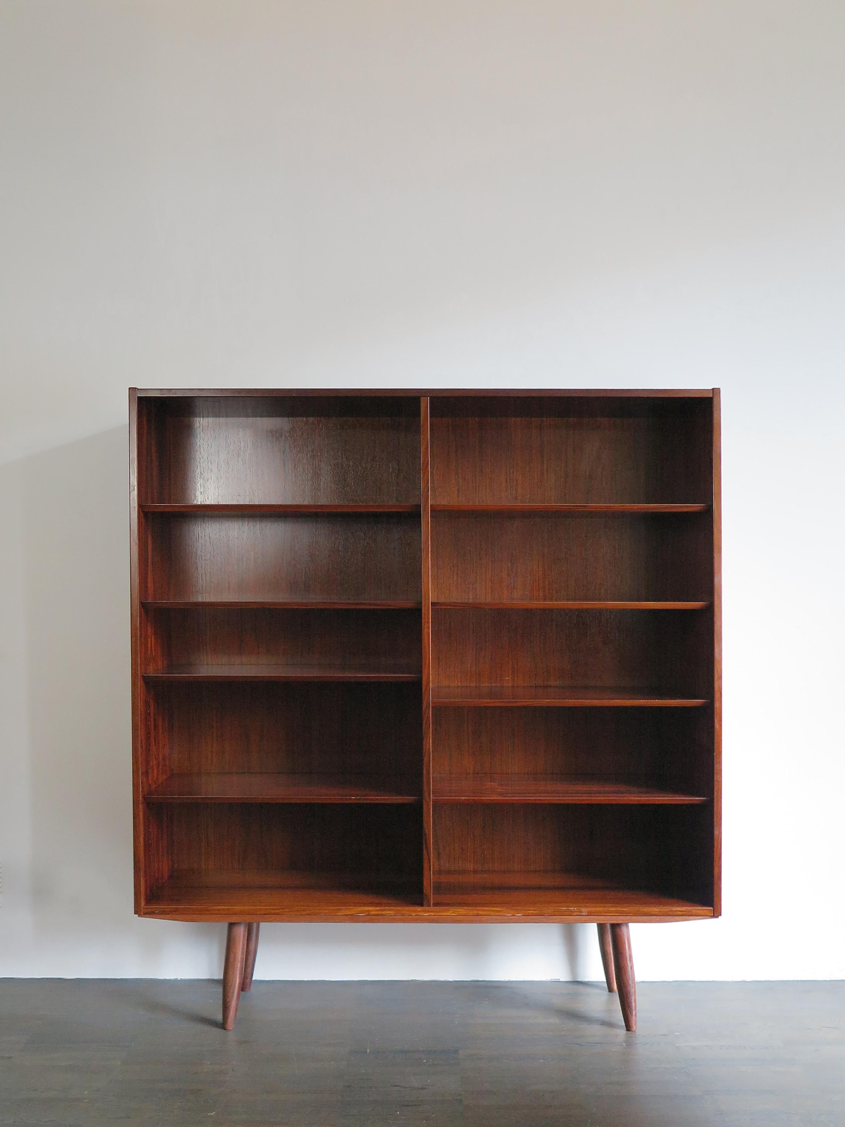 Scandinavian Mid-Century Modern design dark wood bookcase designed by Gunni Omann and produced by Omann Jun Møbelfabrik in the 1960s, variable height position of shelves, Denmark 1960s.

Please note that the bookcase is original of the period and