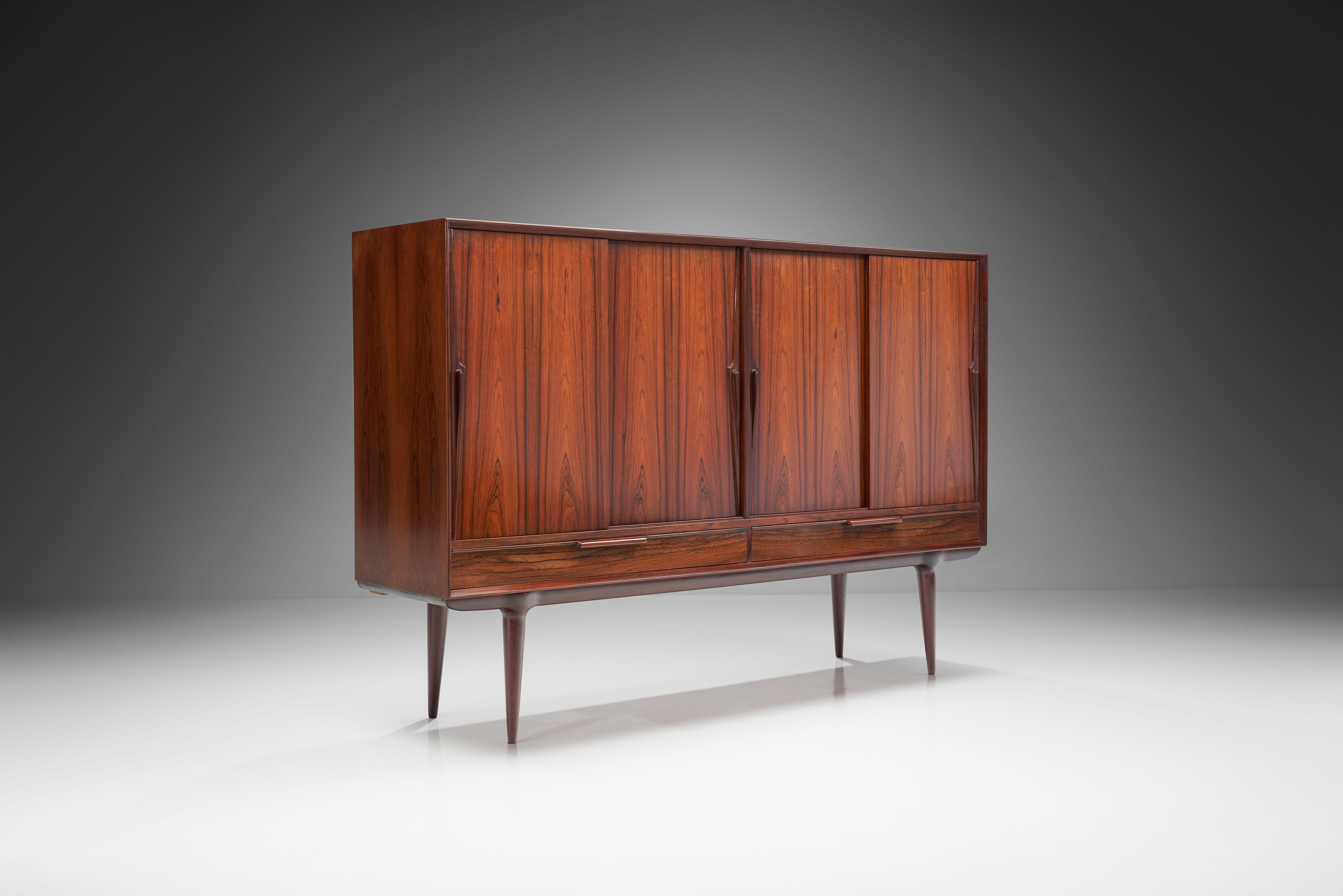 This solid wood sideboard was designed for Omann Jun Møbelfabrik in the mid-20th century. Quality materials and great attention to detail make this “Model 13” sideboard a beautifully constructed, elegant piece. 

The front has two drawers in the