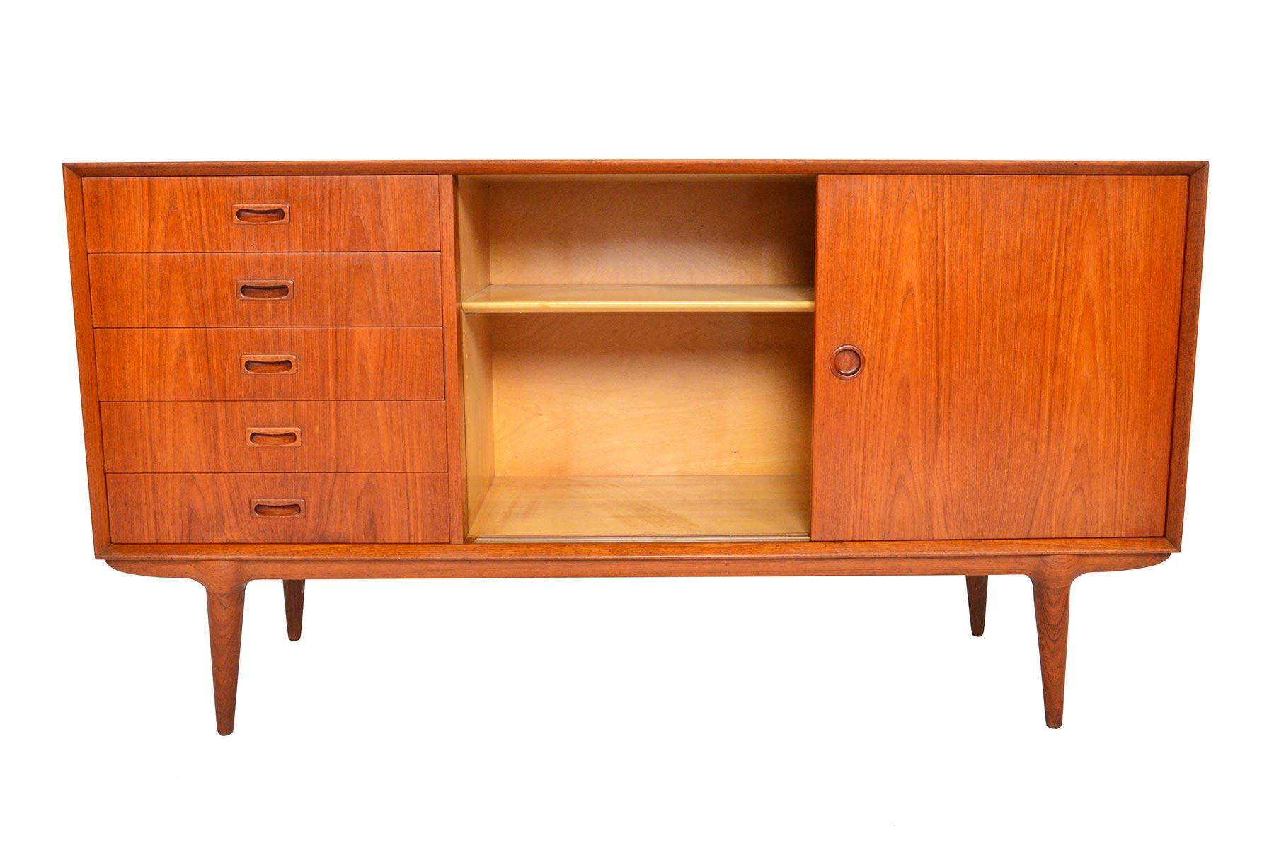 This Danish modern medium sized credenza was designed as Model 3 by Gunni Omann for Omann Jun’s Møbelfabrik in 1956. Beautifully constructed, the case holds a bank of drawers and a large sliding door cabinet with an adjustable shelf. Omann’s