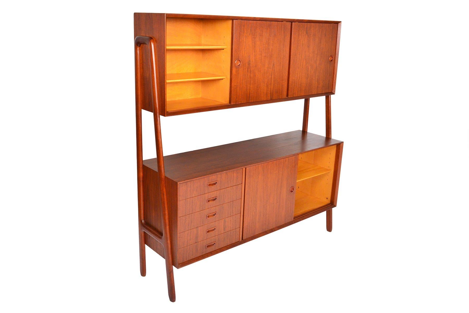 This wonderful Danish modern two-tier teak credenza was manufactured by Gunni Omann as Model 3 in the 1960s. Exterior legs support two large credenzas providing ample storage while creating an open an airy silhouette. The top tier offers three