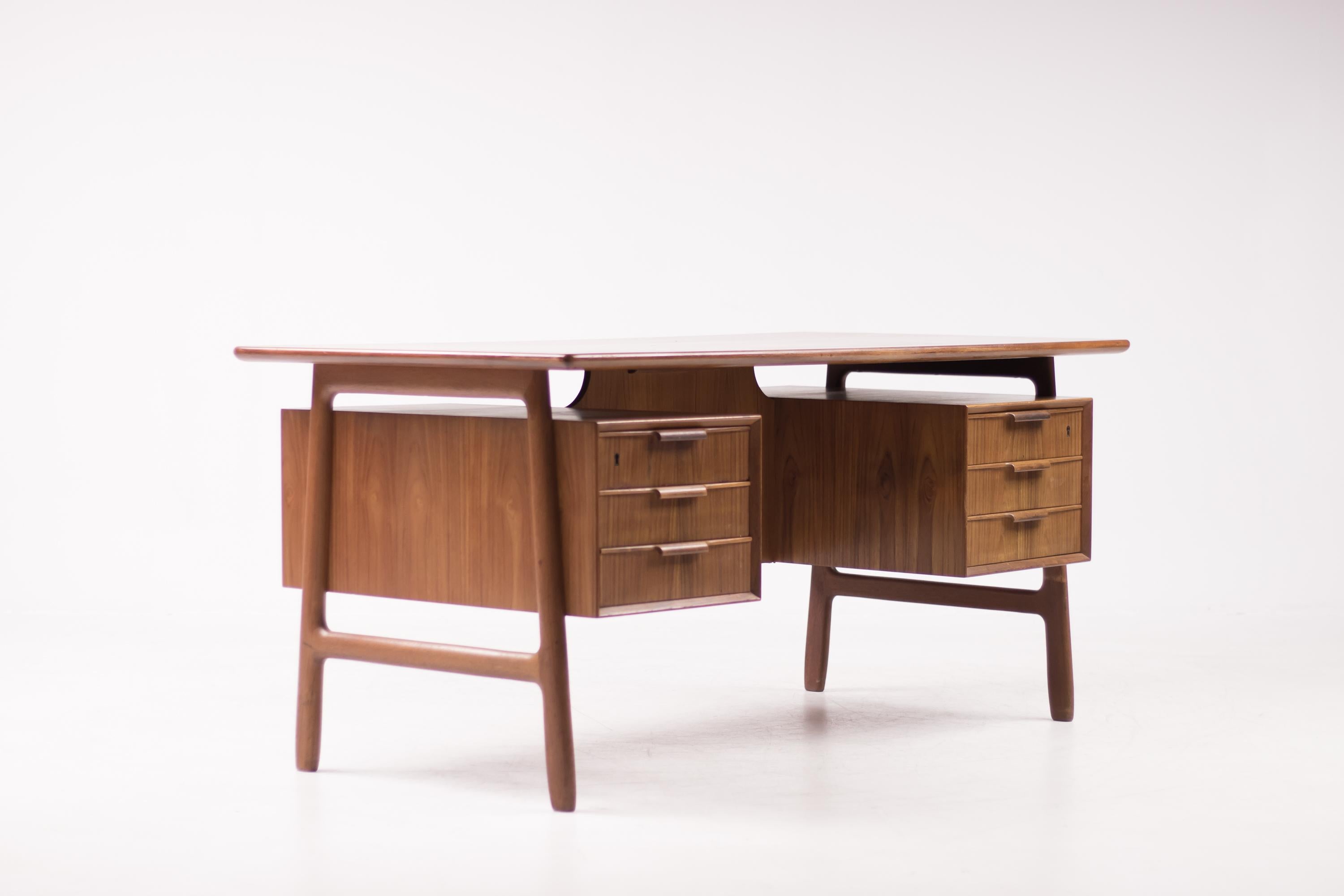 Teak writing desk designed by Gunni Omann for Omann Jun Mobelfabrik Denmark.
Perfectly suitable for free-standing use, with several compartments at the frontside of the desk. 
Though very modern in design, this desk has many beautifully carved