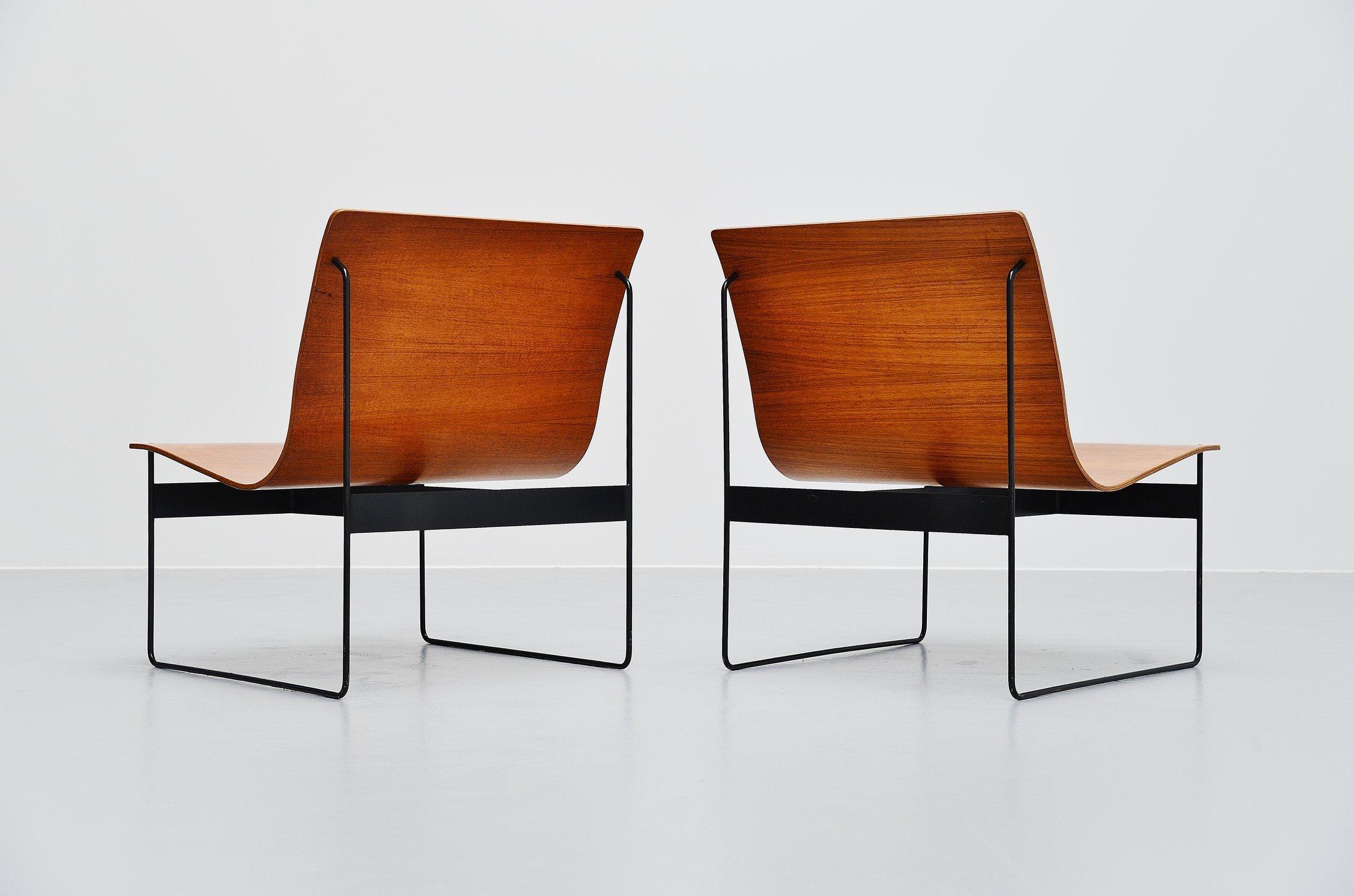 Amazing pair of plywood lounge chairs designed by Günter Renkel and manufactured by Rego, Germany, 1959. These chairs are made of teak plywood and have solid metal sophisticated sledge frames, black lacquered. The chairs have a very nice and warm