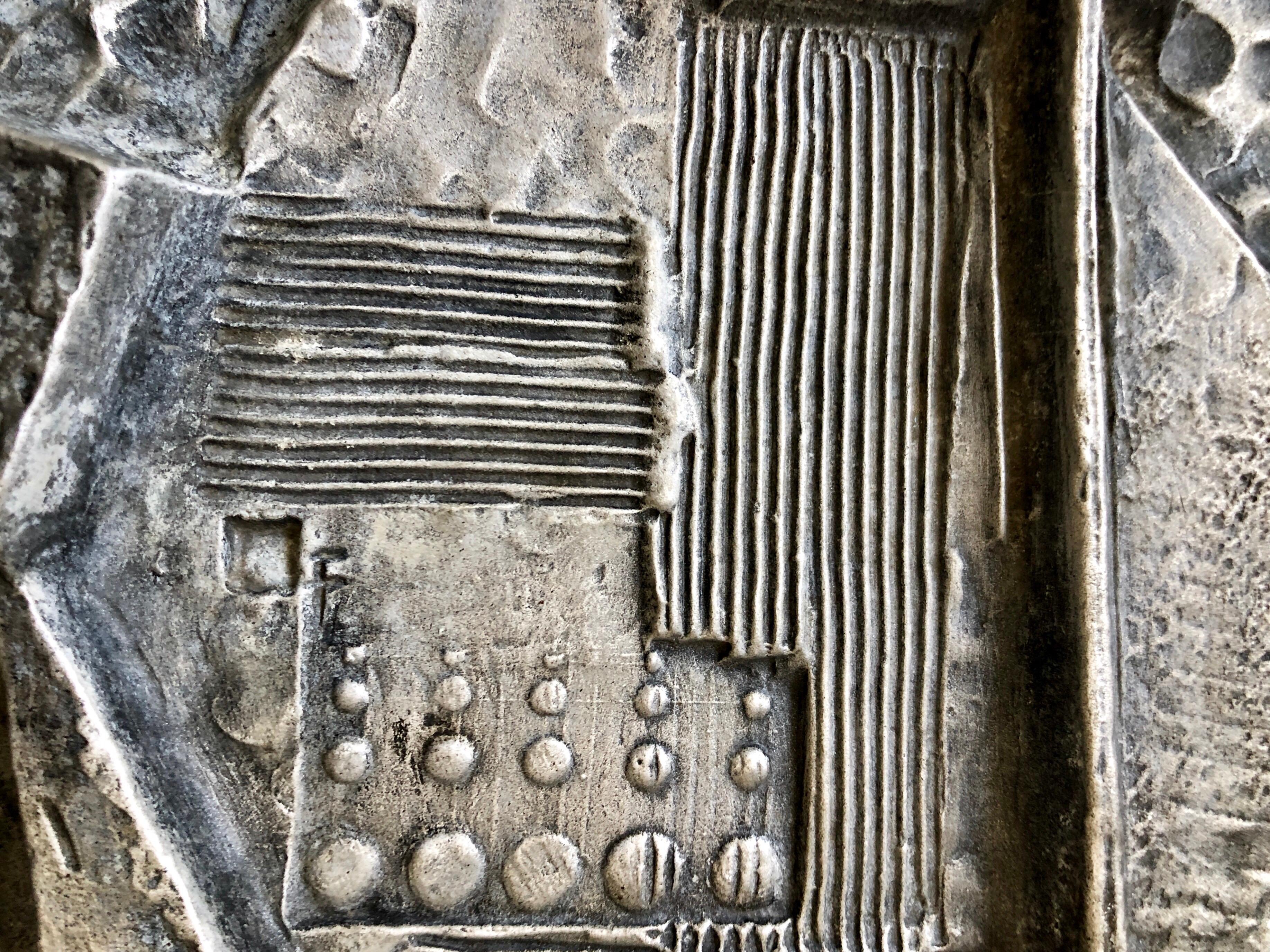 This piece is cast in some sort of stone or grainy resin material and then silvered with metallic paint. 
it is signed and dated. 
Gunther Gerzso was born on June 17, 1915 in Mexico City during the Revolution. His parents were Oscar Gerzso, a