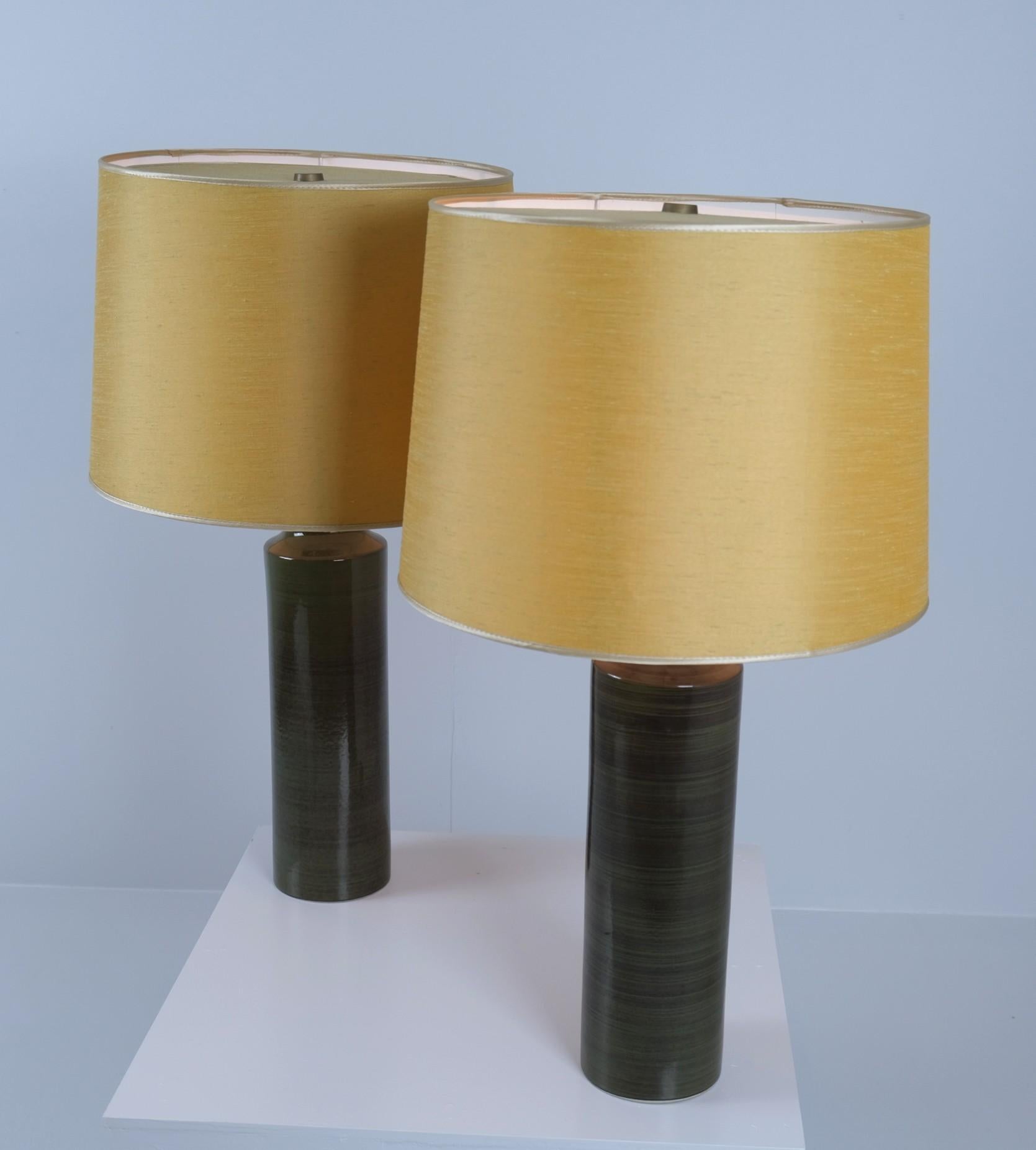 Zwei majestätische Tischlampen, entworfen von Gunvor Olin-Grönqvist für Arabia in den 1960er Jahren. Die Lampen sind sehr groß und ausgeprägt. Mit einem grünlichen Keramikfuß und gelben Stoffschirmen. Beide Lampen tragen die Aufschrift 