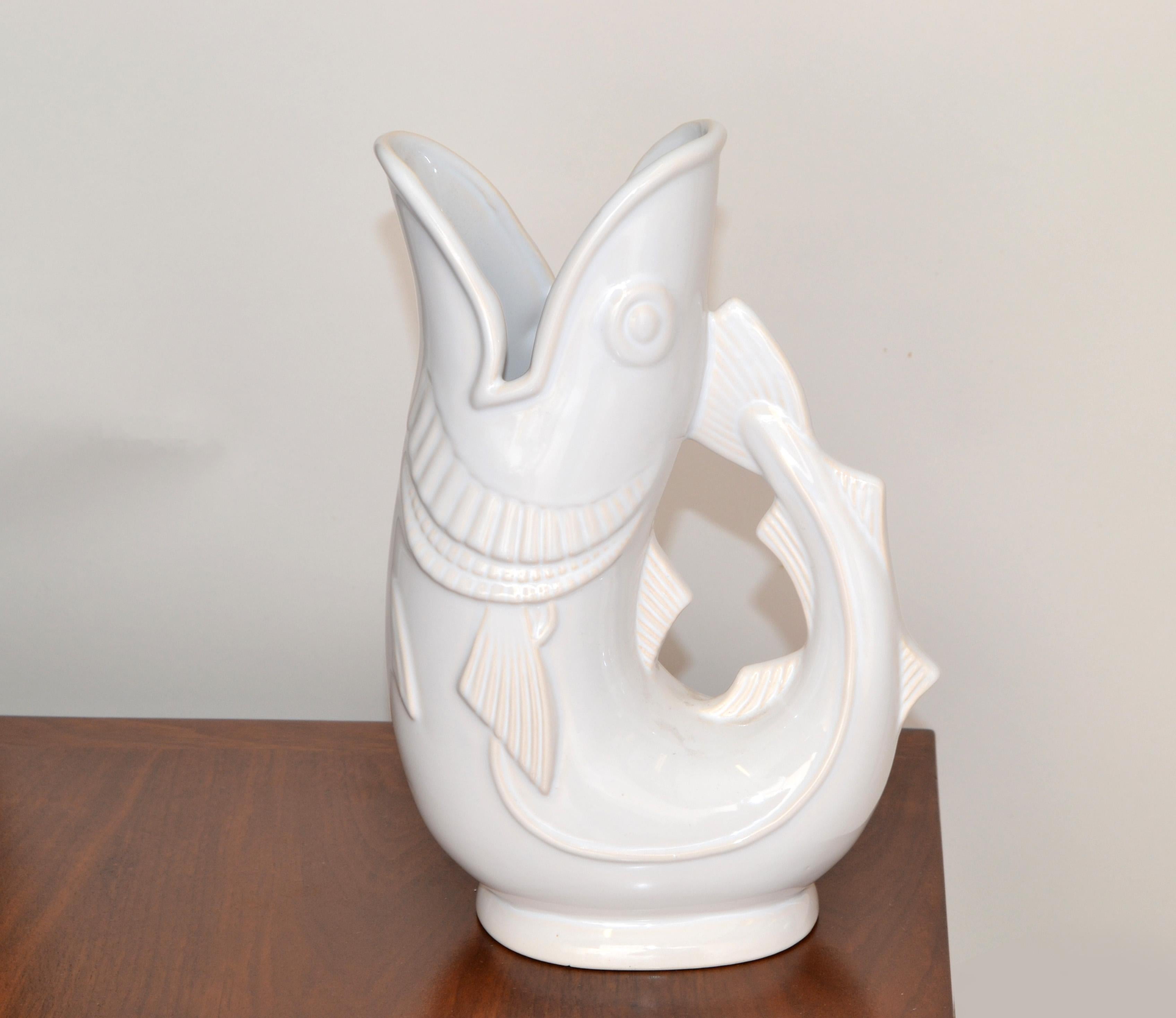This Vintage Shreve Crump & Low Boston Gurgling Cod Fish Pitcher 11.25 inches tall in white glazed Ceramic and made in England.
The Decanter is marked at the base, Made in England for Shreve Crump & Low Company Boston. 
This happy Animal Sculpture