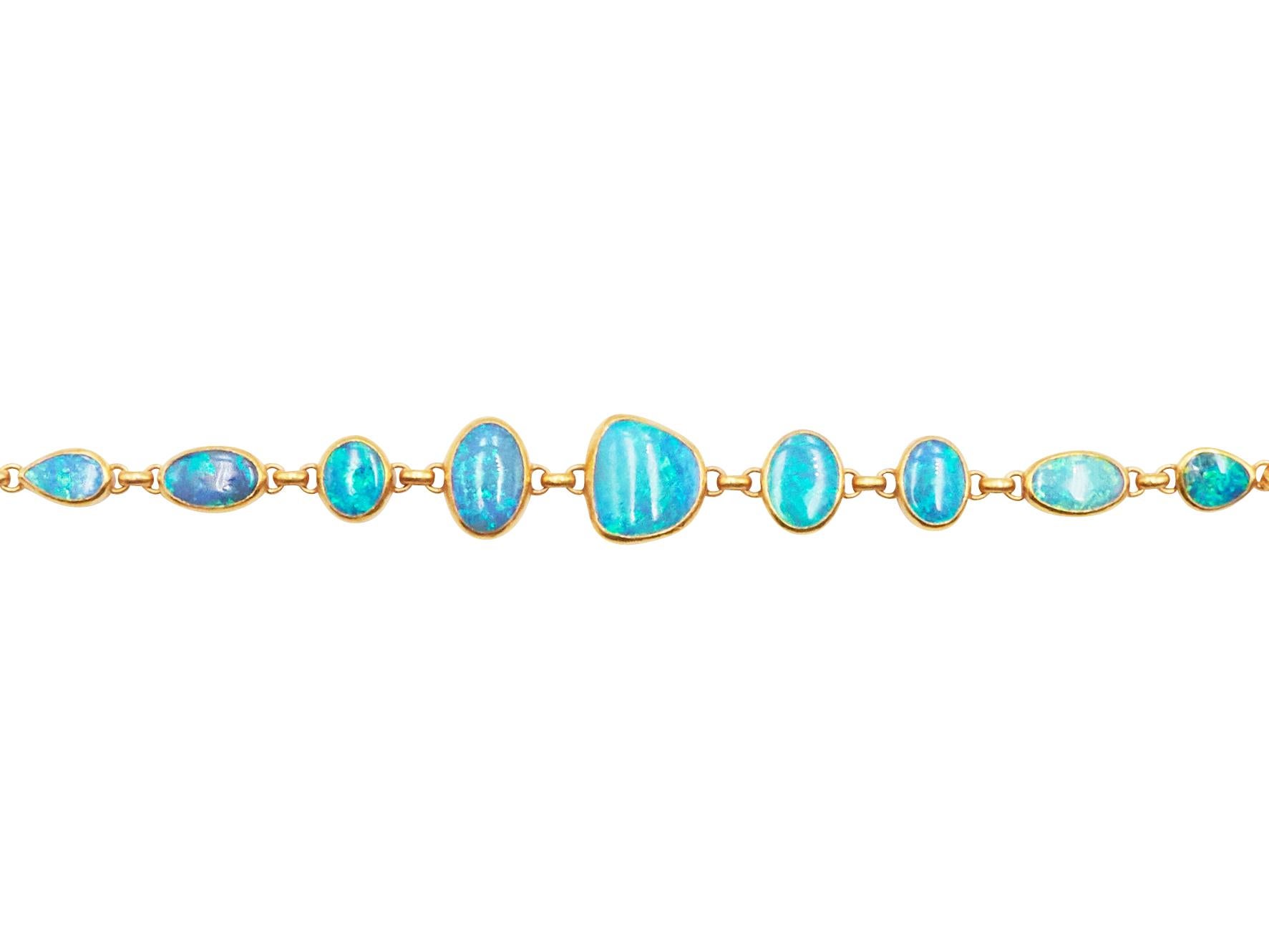 GURHAN all around one-of-a-kind bracelet in 24 Karat hammered yellow gold featuring (9) mixed sized and mixed shaped cabochon Australian Opals, 21.70 cts. Adjustable length from 7.5